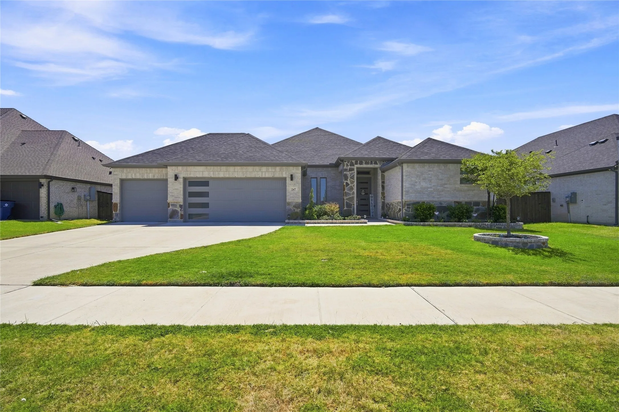 Stone and brick exterior with a dark gray shingle roof