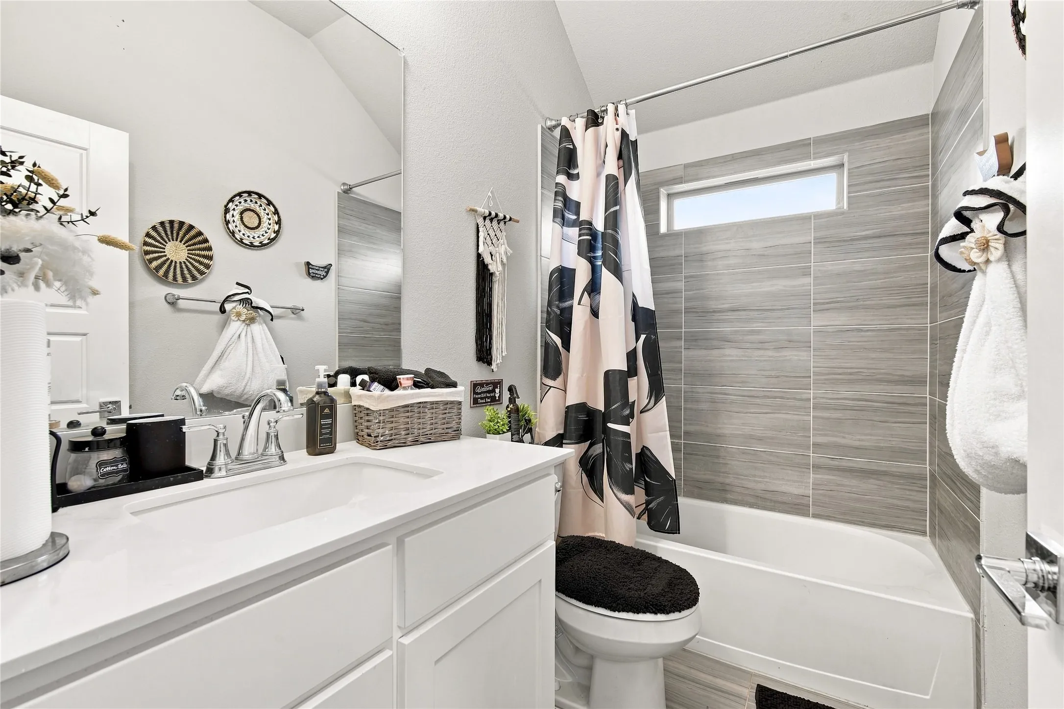 White vanity with an integrated rectangular sink, chrome faucet, and expansive wall mirror