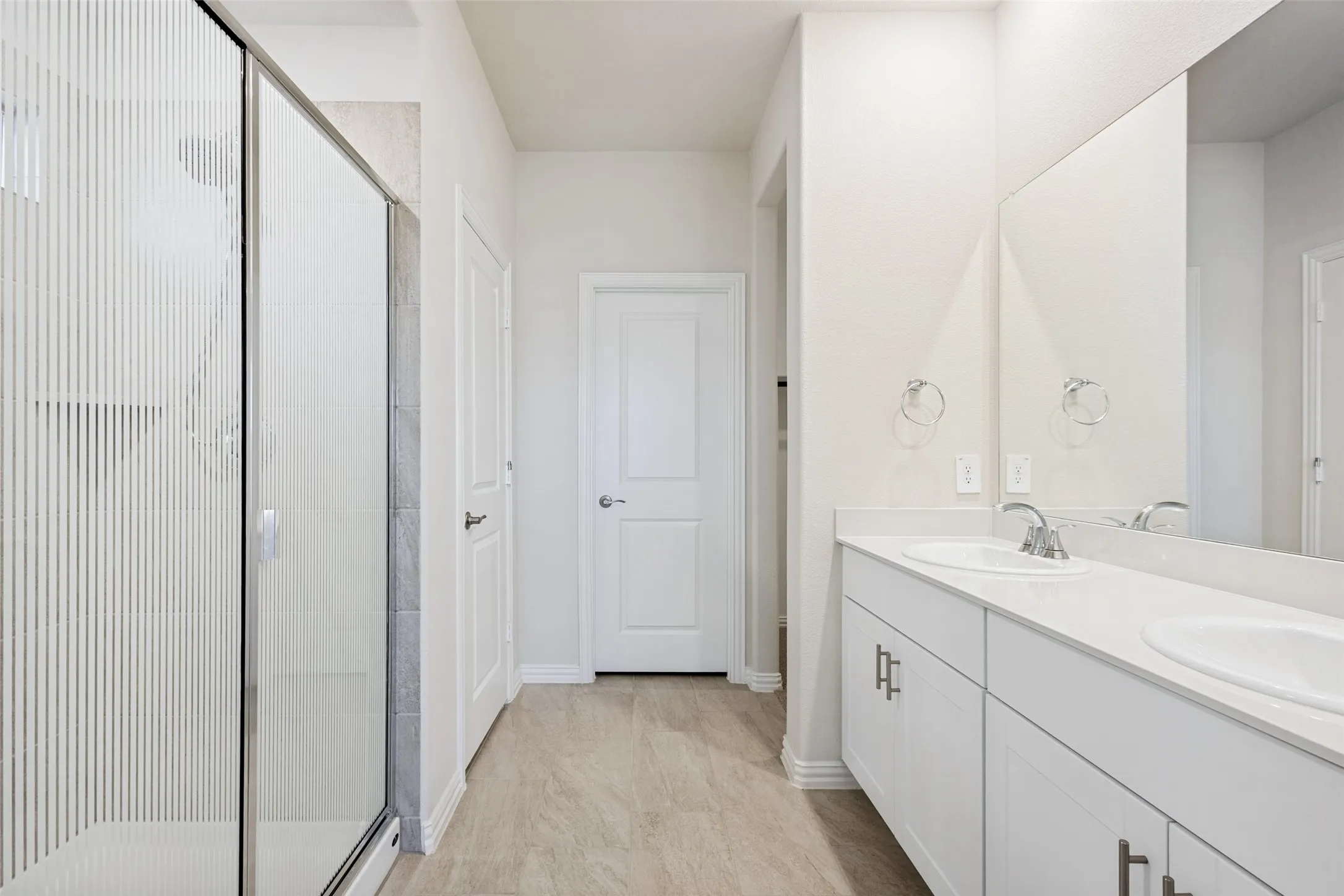 Dual vanity with undermount sinks, chrome fixtures, and white cabinetry