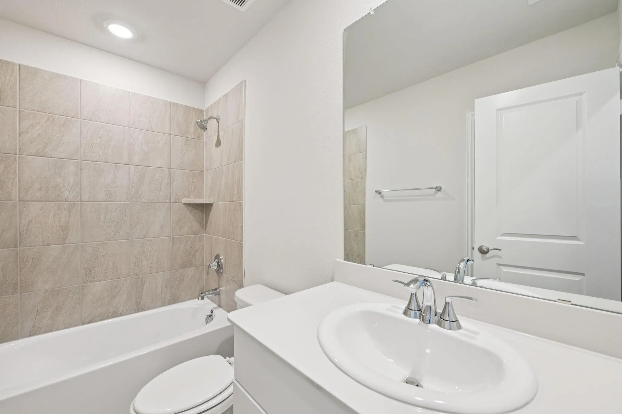 White vanity with an integrated sink, polished chrome faucet, and expansive mirror
