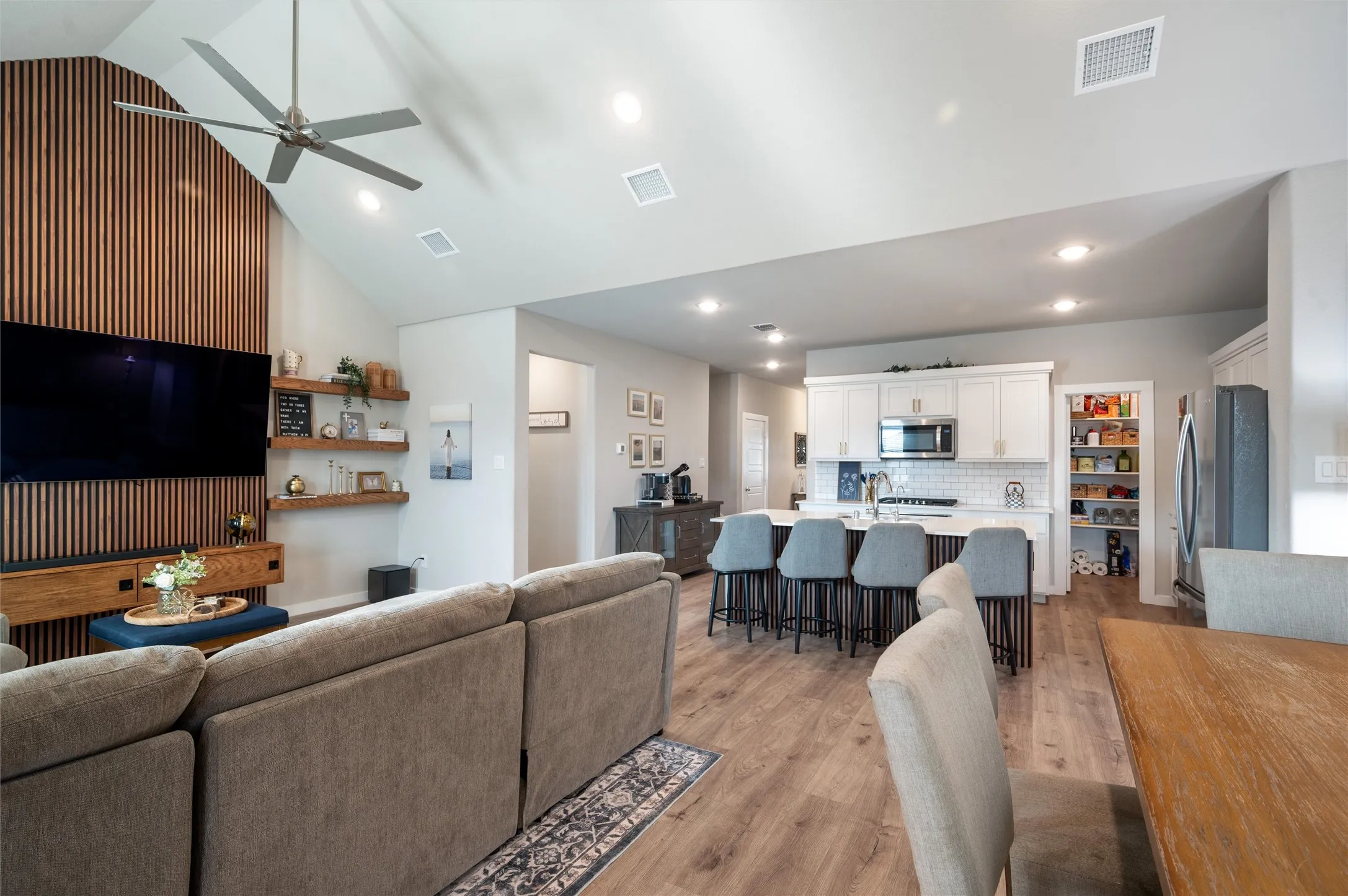 Vaulted ceiling featuring a contemporary ceiling fan, wood-finish flooring, and recessed lighting