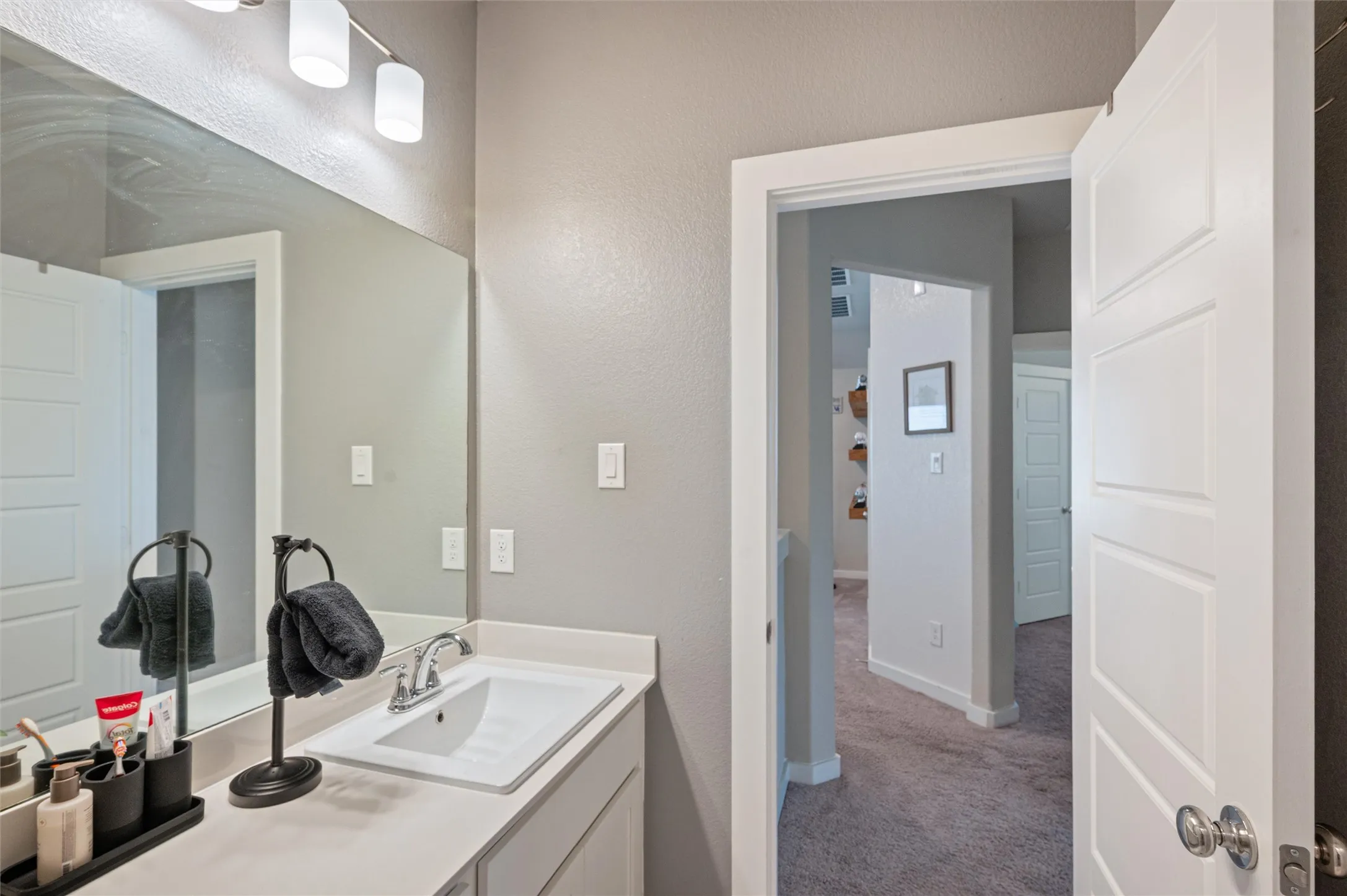 Vanity with integrated sink, polished chrome faucet, and rectangular mirror
