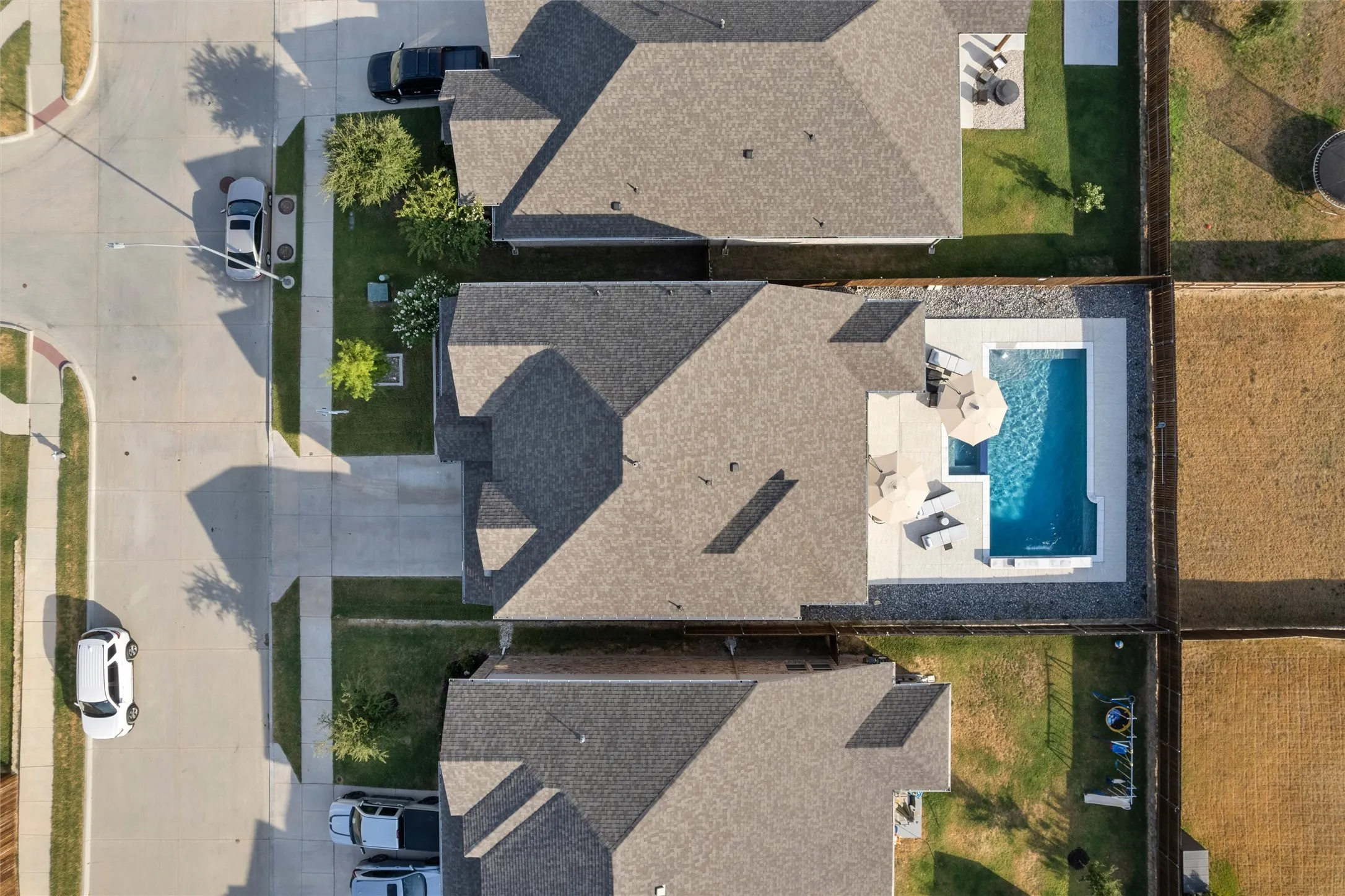 Private backyard swimming pool with a surrounding hardscape patio