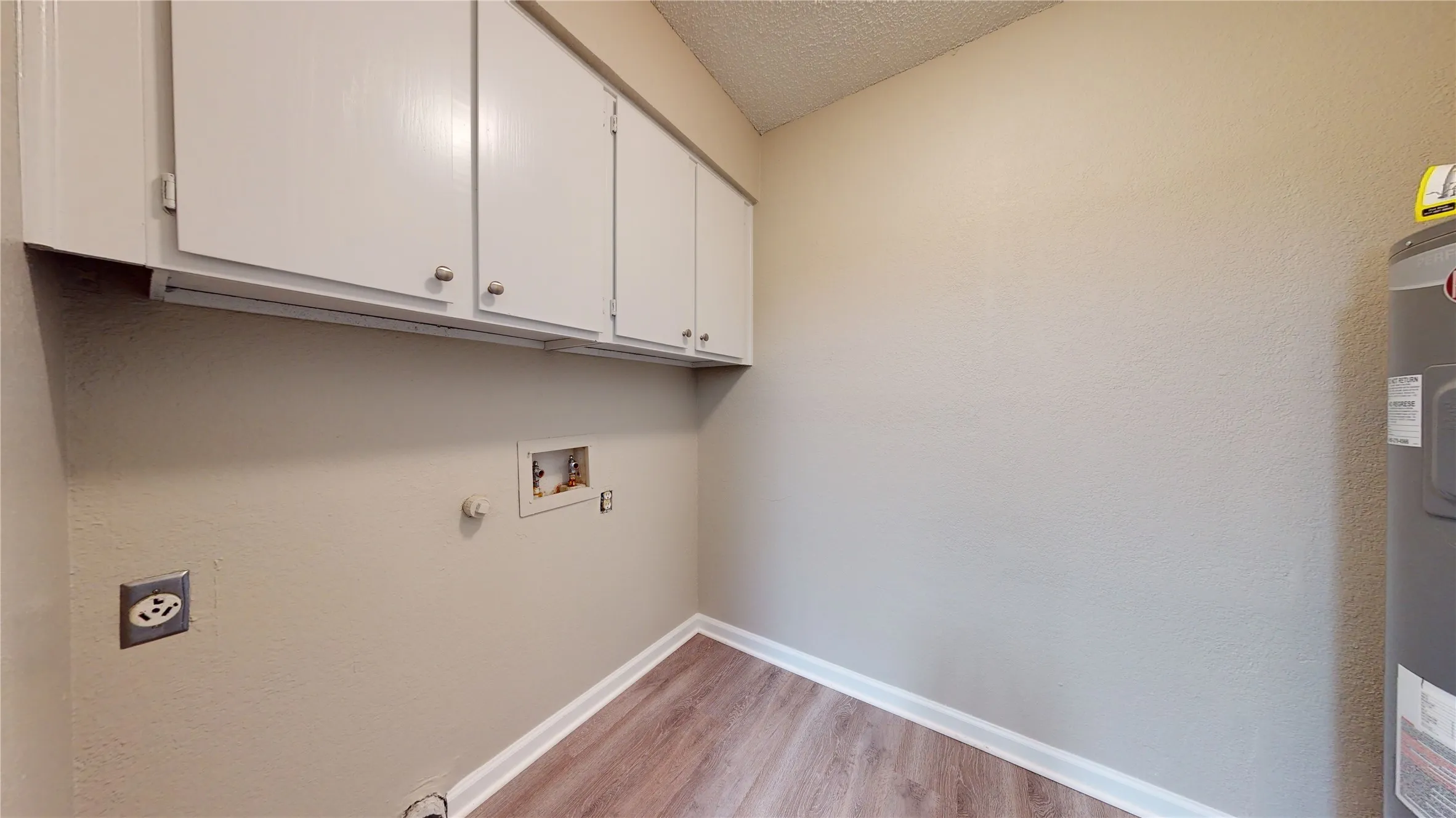 White cabinetry, wood-finish flooring, and light-toned walls