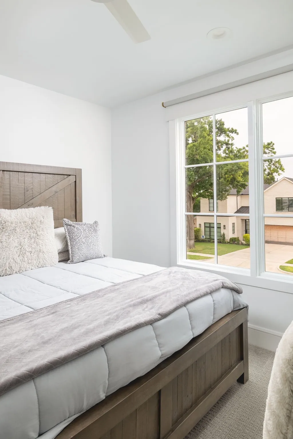 Recessed lighting, ceiling fan, and large windows with white trim
