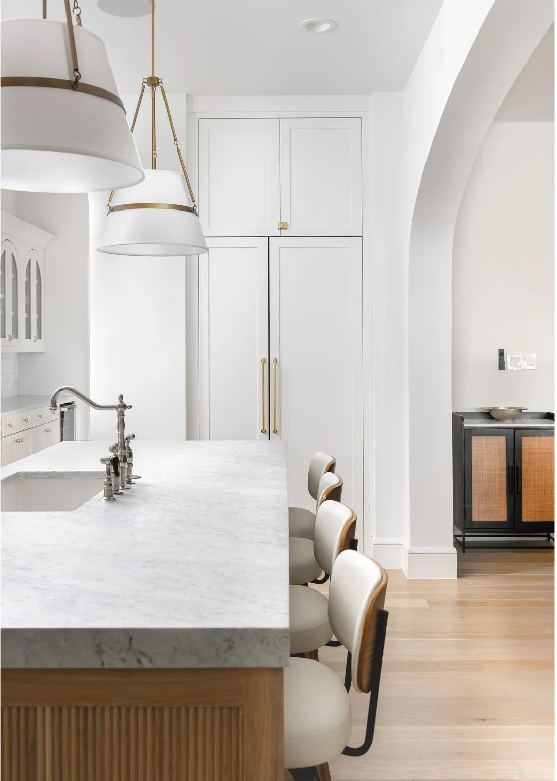 Kitchen island with a light-toned countertop and paneled wood-finish base