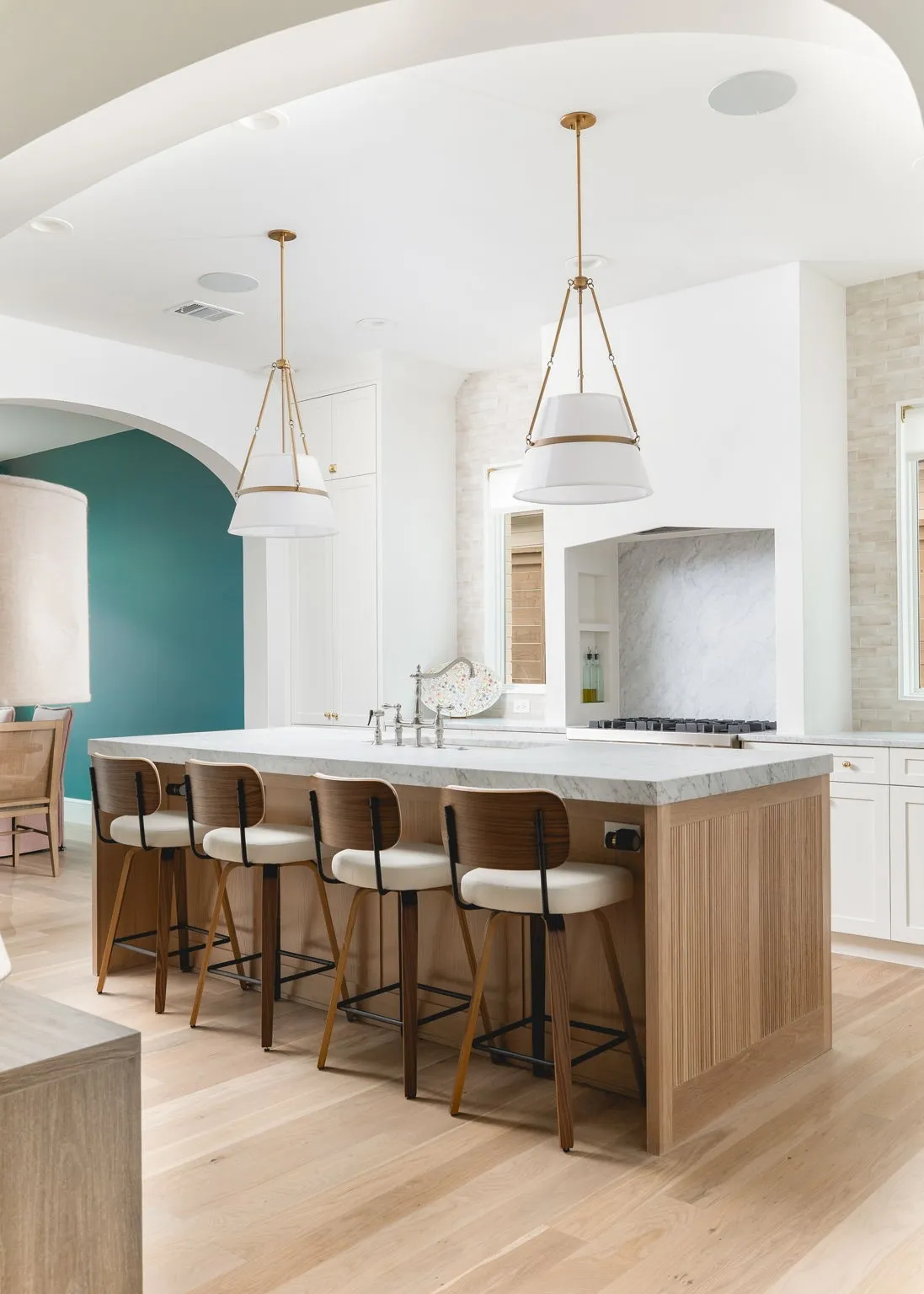 Kitchen island with a light wood-finish base, stone countertop, and integrated sink