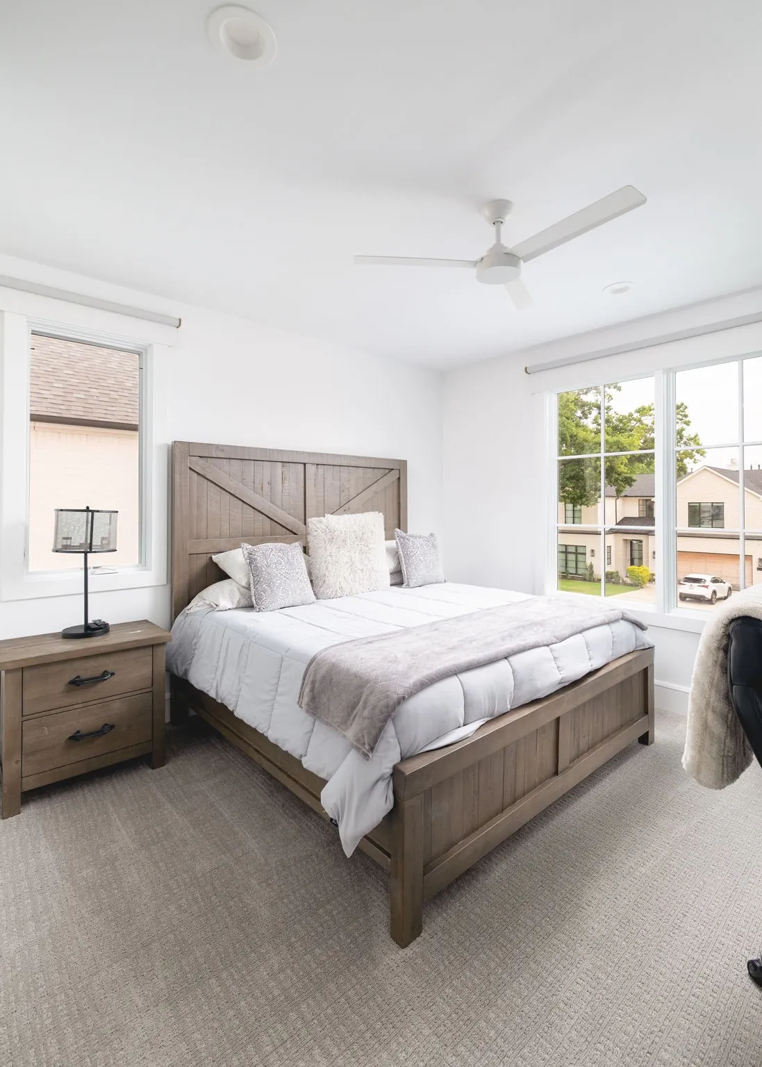 Recessed lighting, ceiling fan, and large windows with roller shades