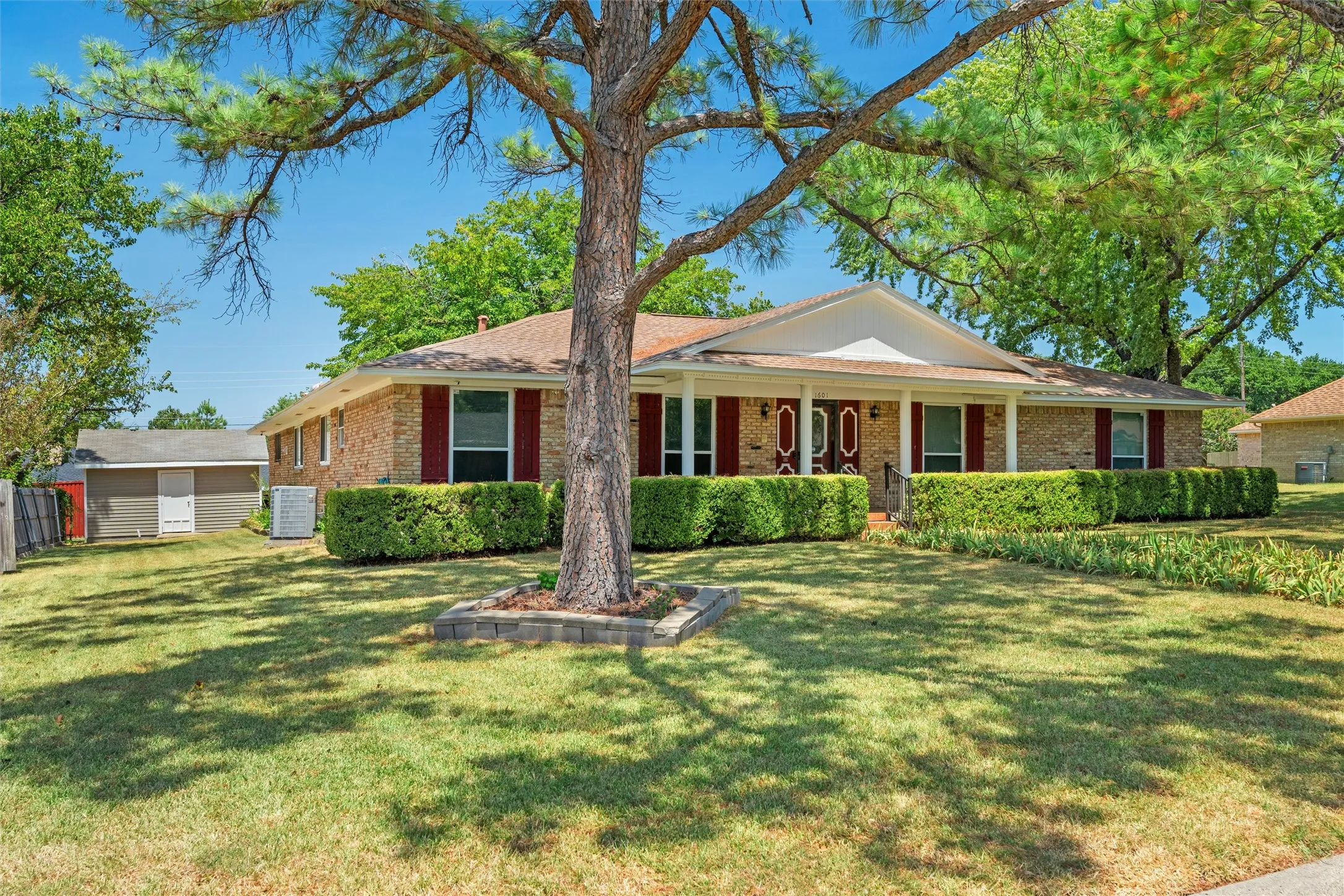 Brick exterior with a covered front porch and red shutters