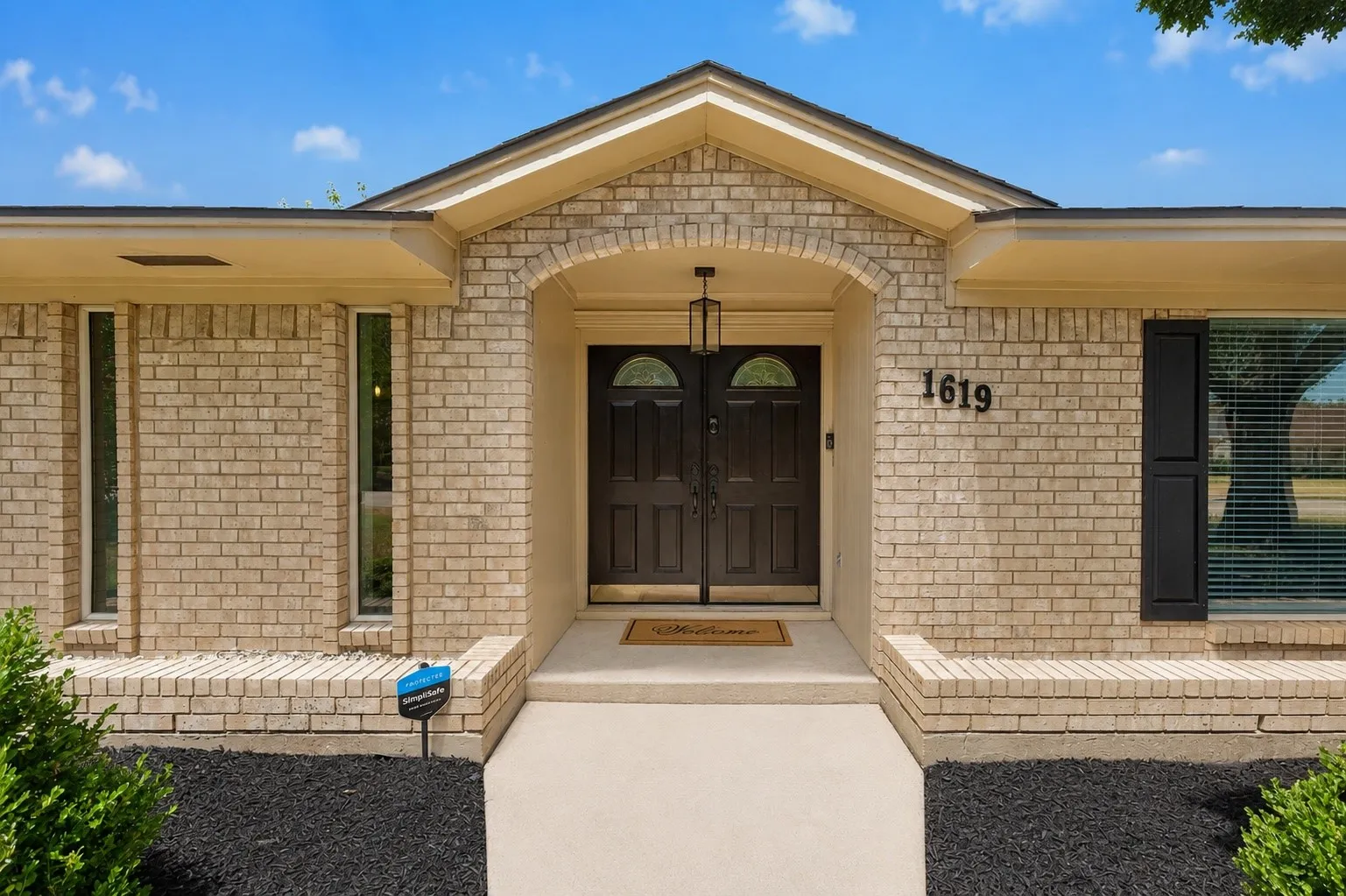 Brick exterior with an arched entryway and double front doors