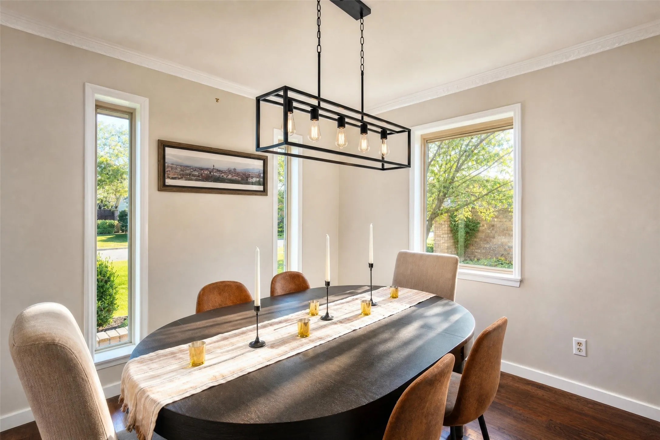 Hardwood flooring, crown molding, modern linear chandelier, and multiple windows