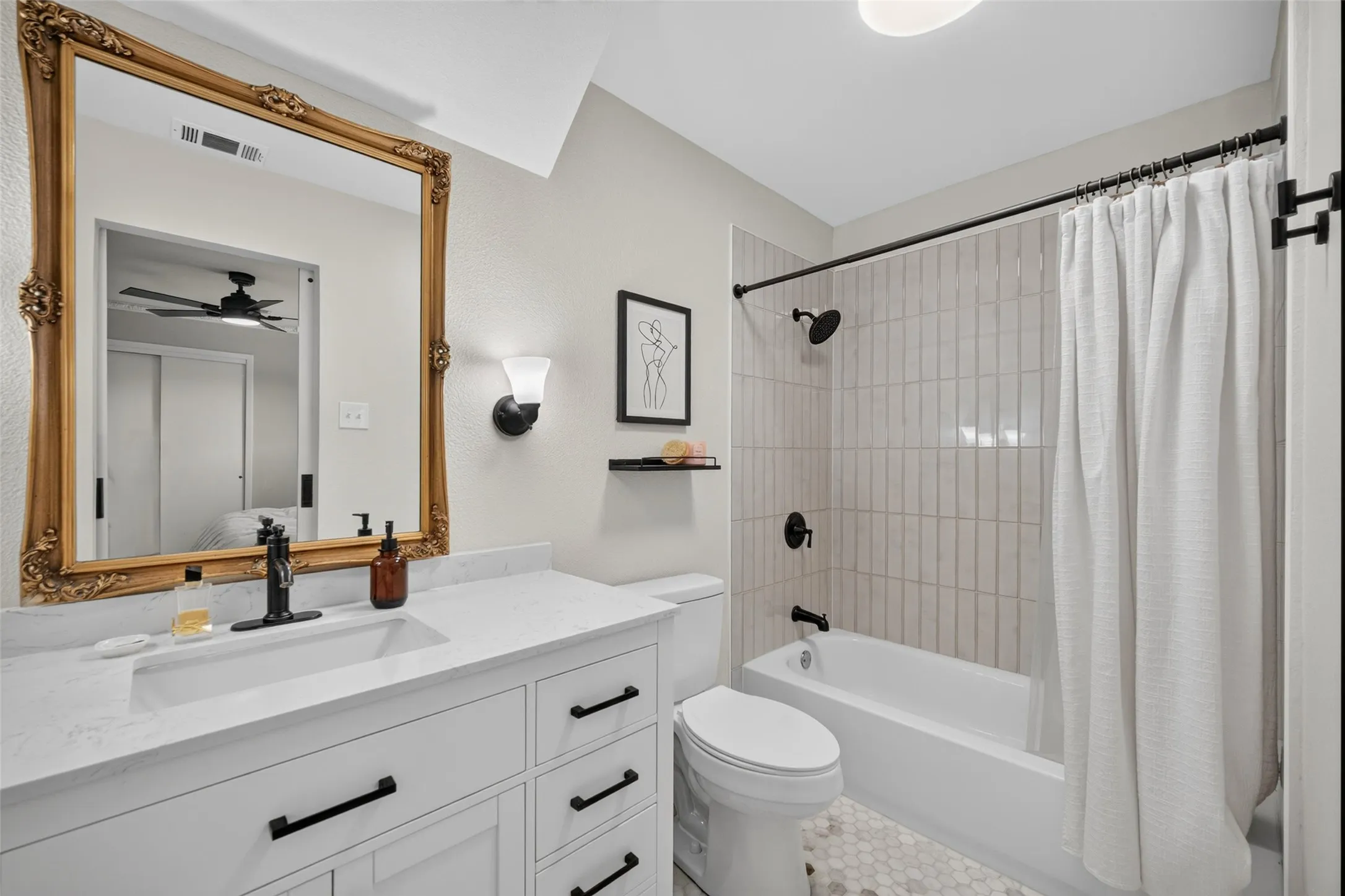 White vanity with black hardware, white countertop, and integrated sink