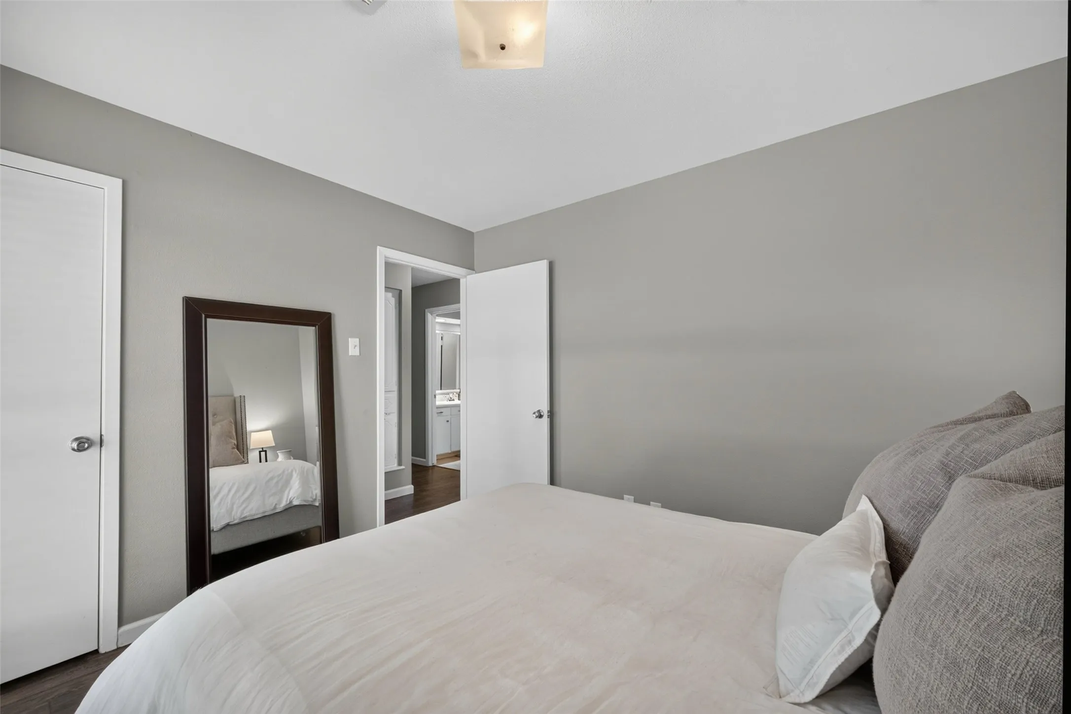 Wood-finish flooring, light grey wall paint, and white trim throughout