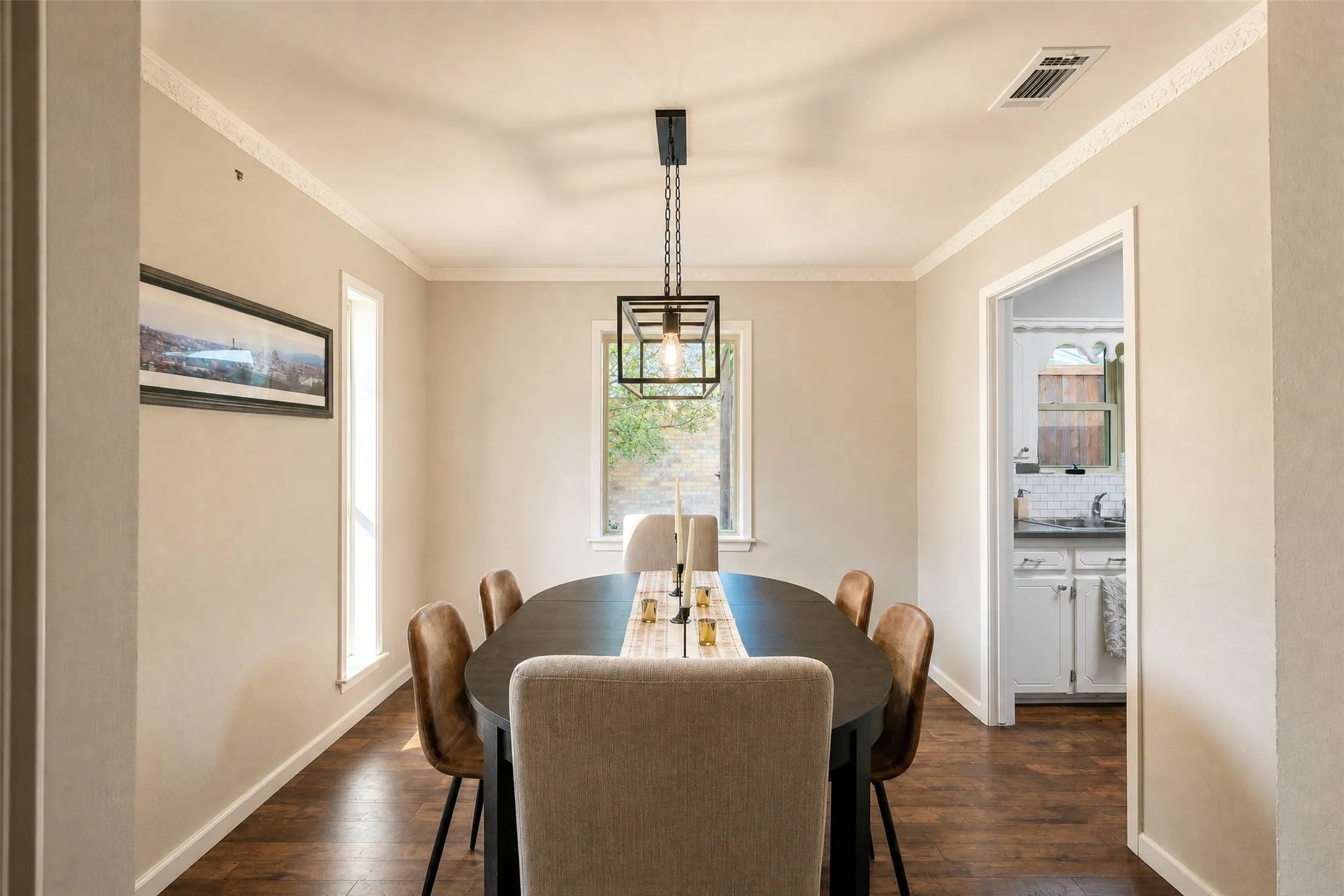 Wood-finish flooring with crown molding and white trim