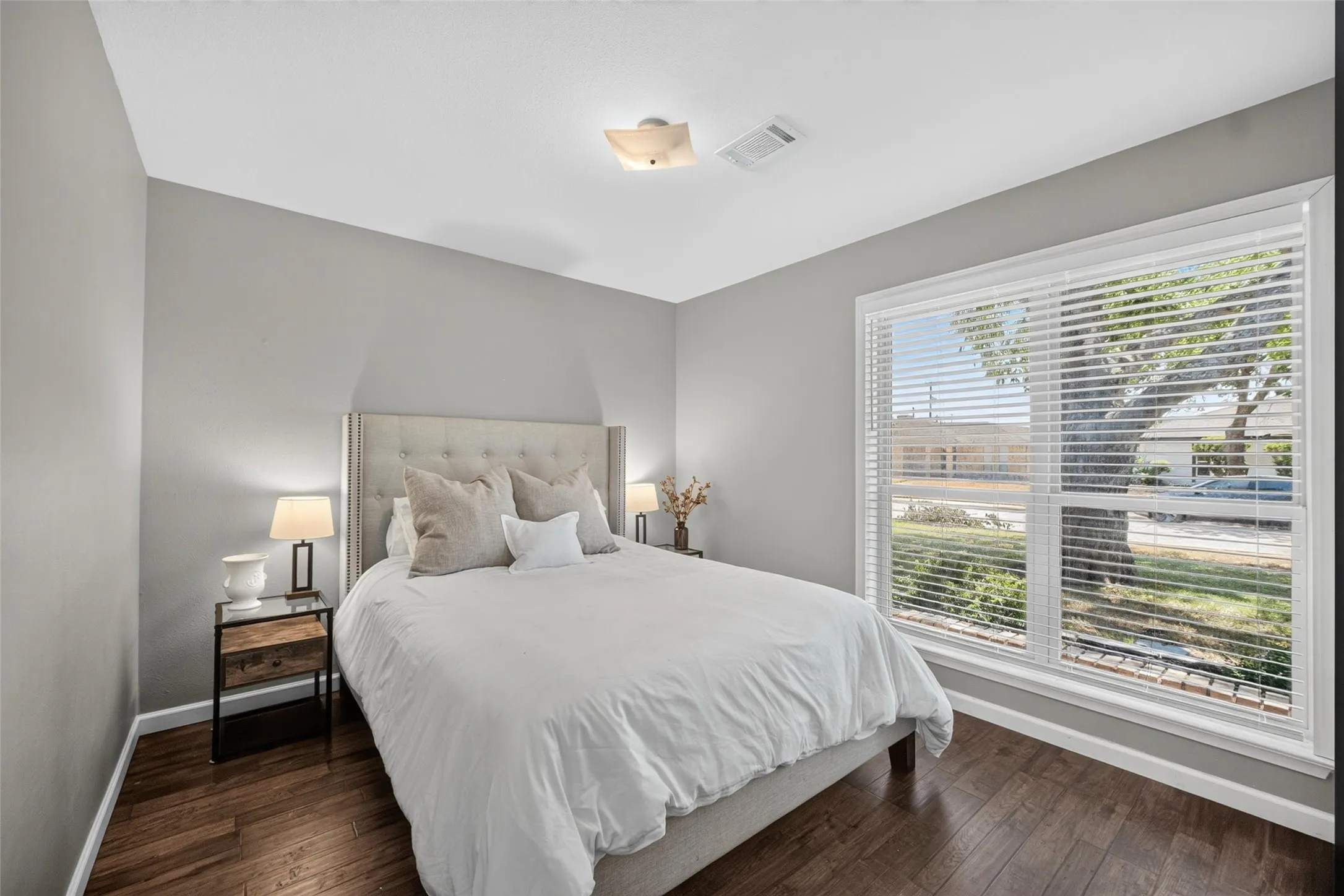 Wood-finish flooring with a large window and window treatments
