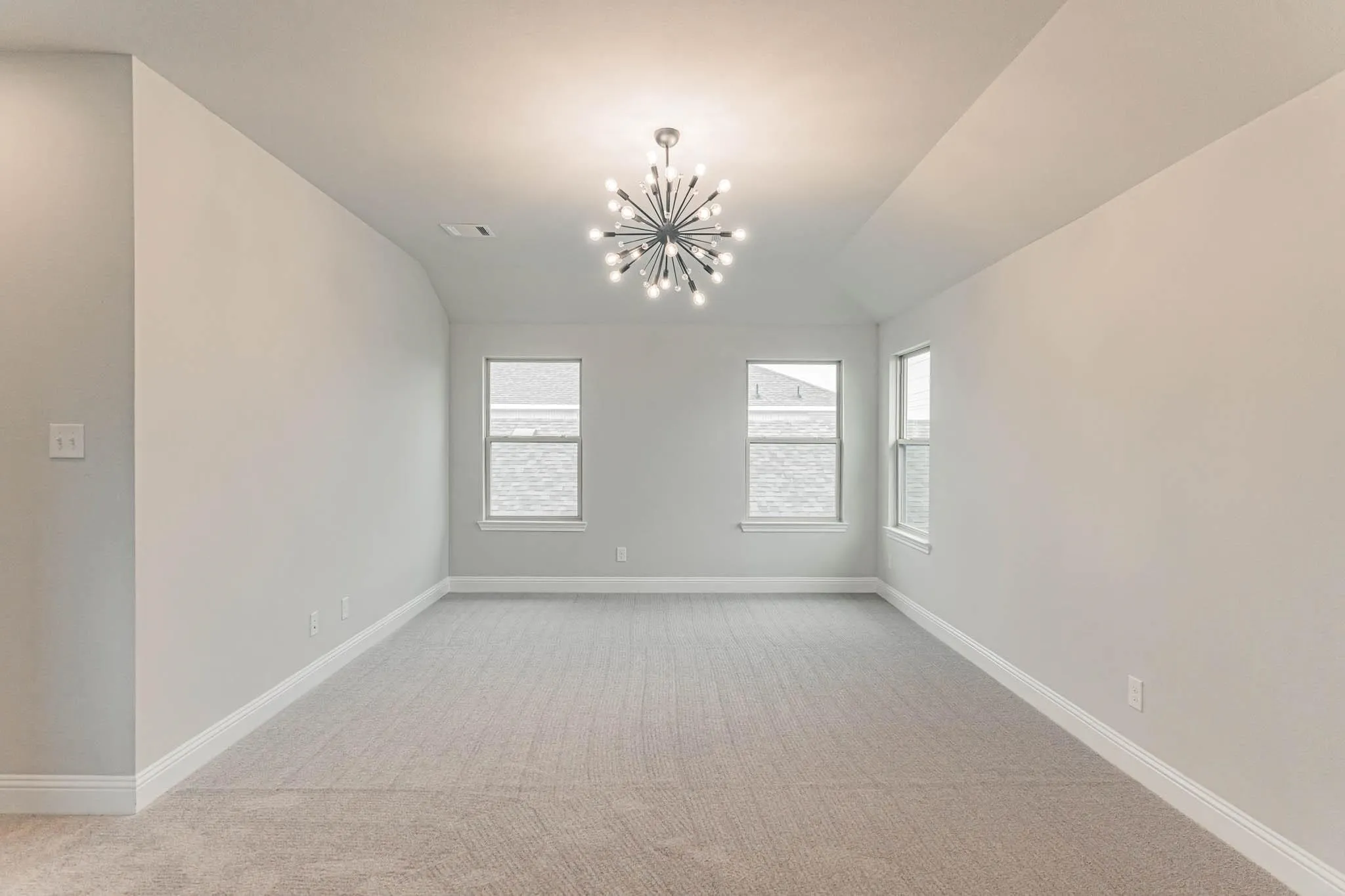 Recessed lighting, contemporary chandelier, carpeted flooring, multiple windows, and vaulted ceiling