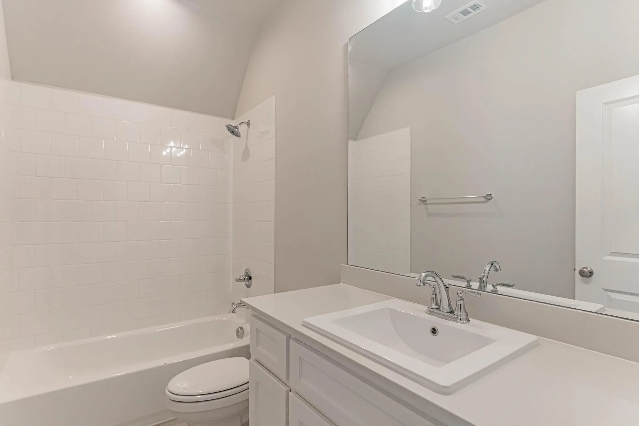 White subway tile shower surround, integrated bathtub, and a single vanity with an undermount sink