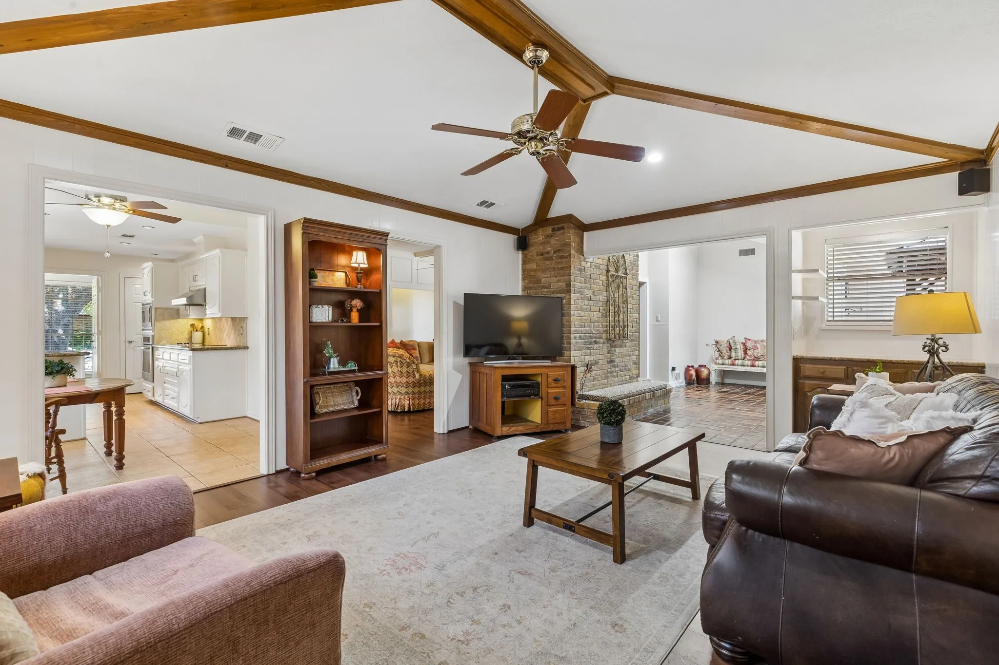 Large family room with beamed ceiling opening to the solarium and kitchen