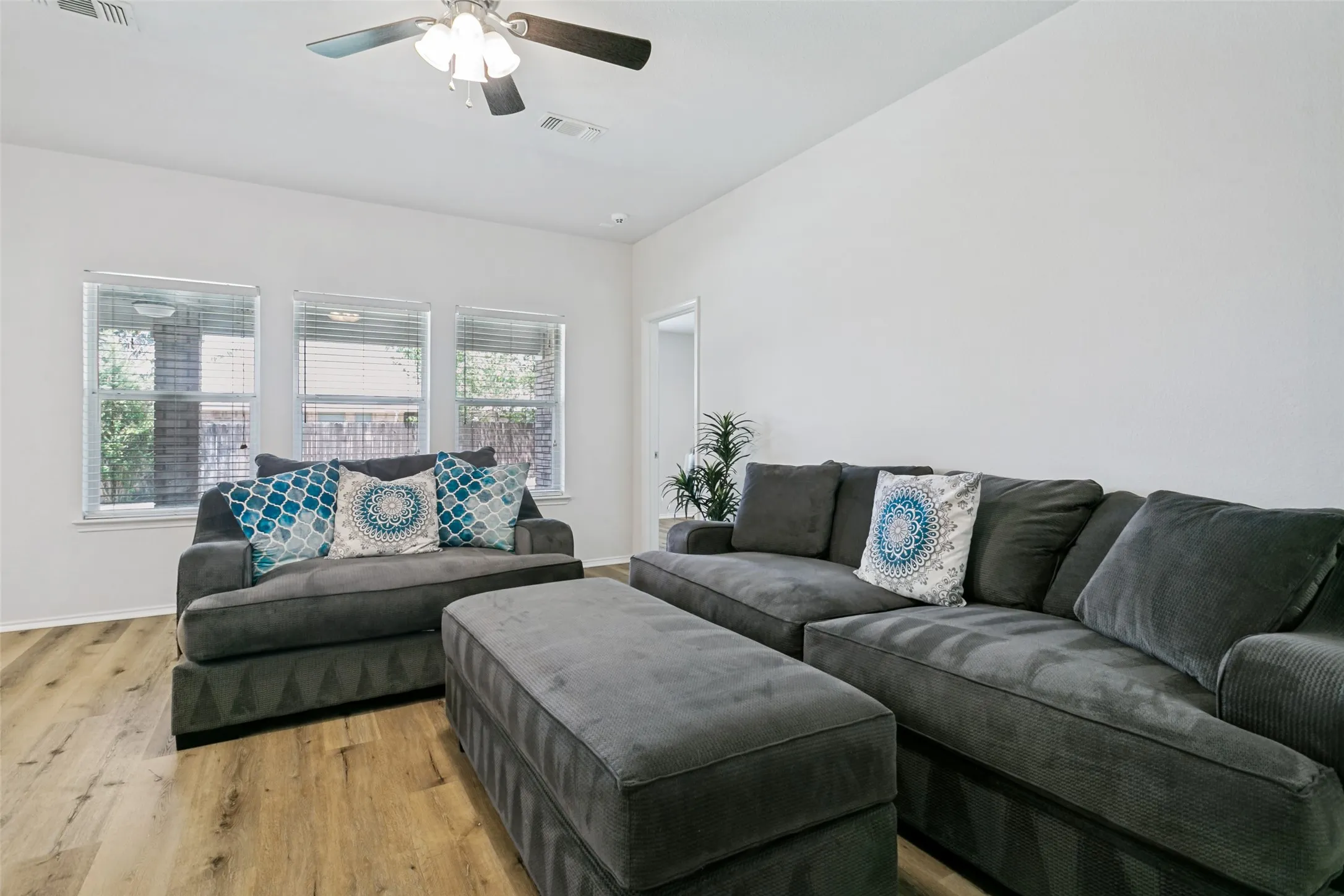 Recessed lighting, wood-finish flooring, and multiple windows with blinds