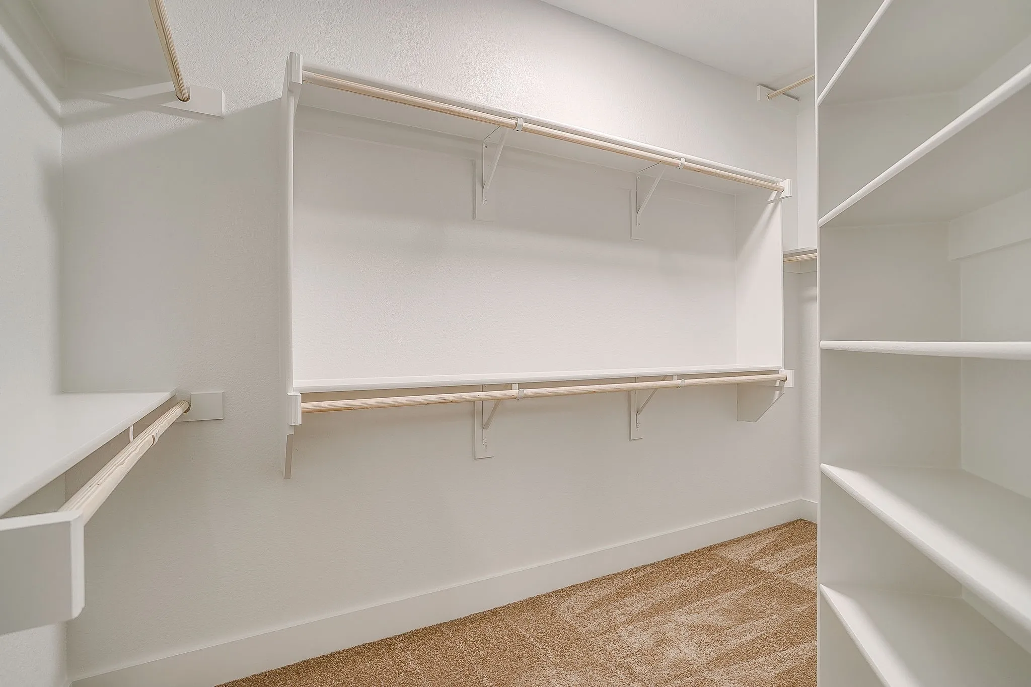 Expansive closet system featuring multiple shelving units and clothing rods