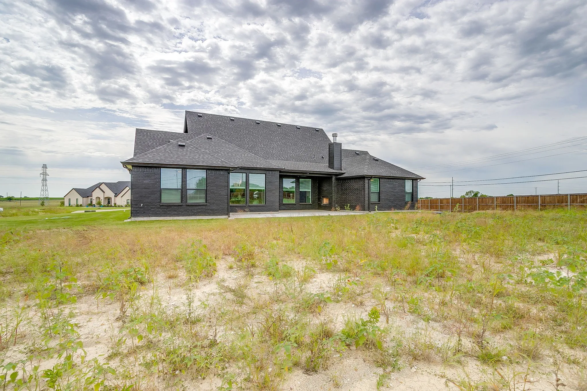 Dark brick exterior with a dark shingle roof