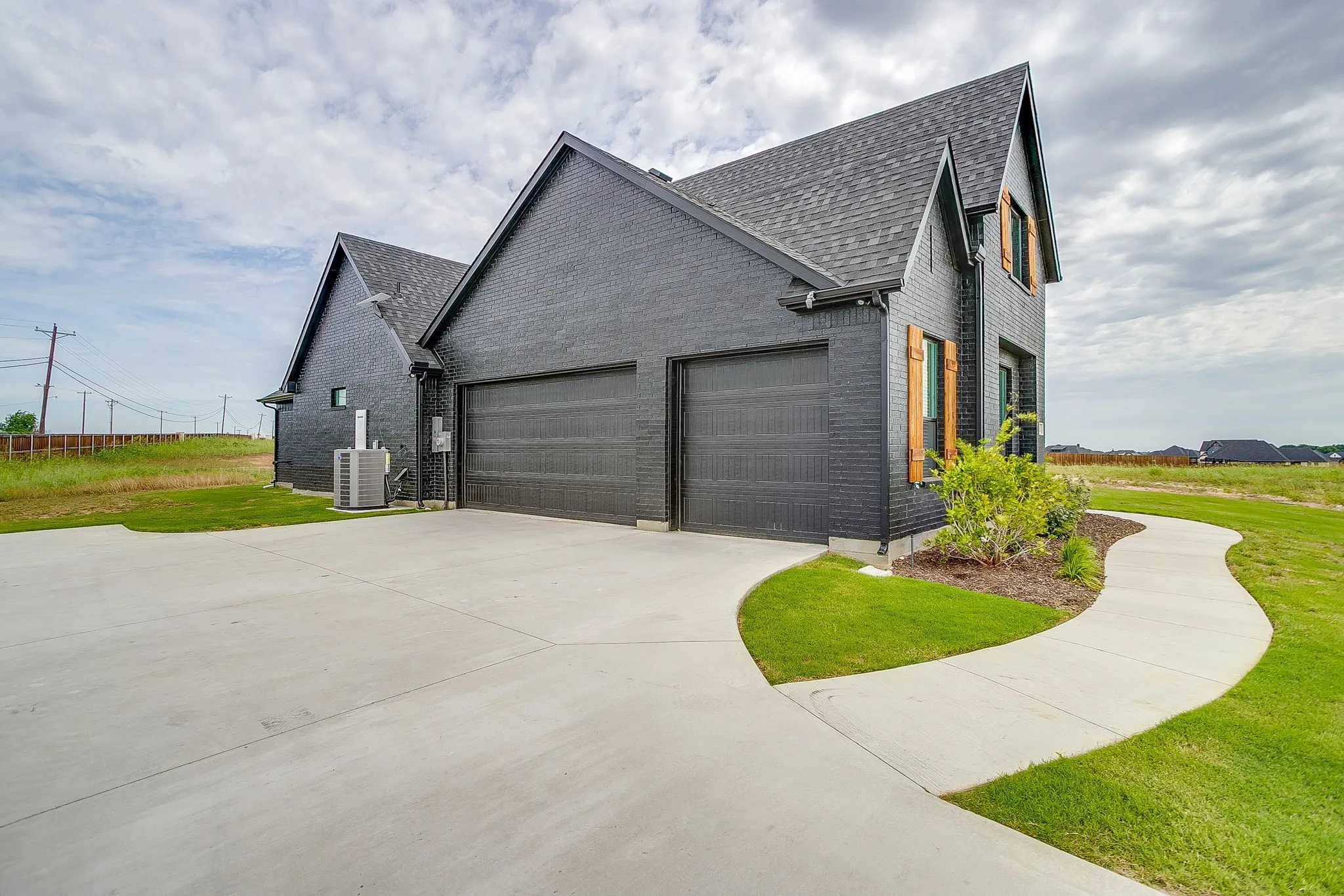 Modern black brick exterior with a multi-car garage