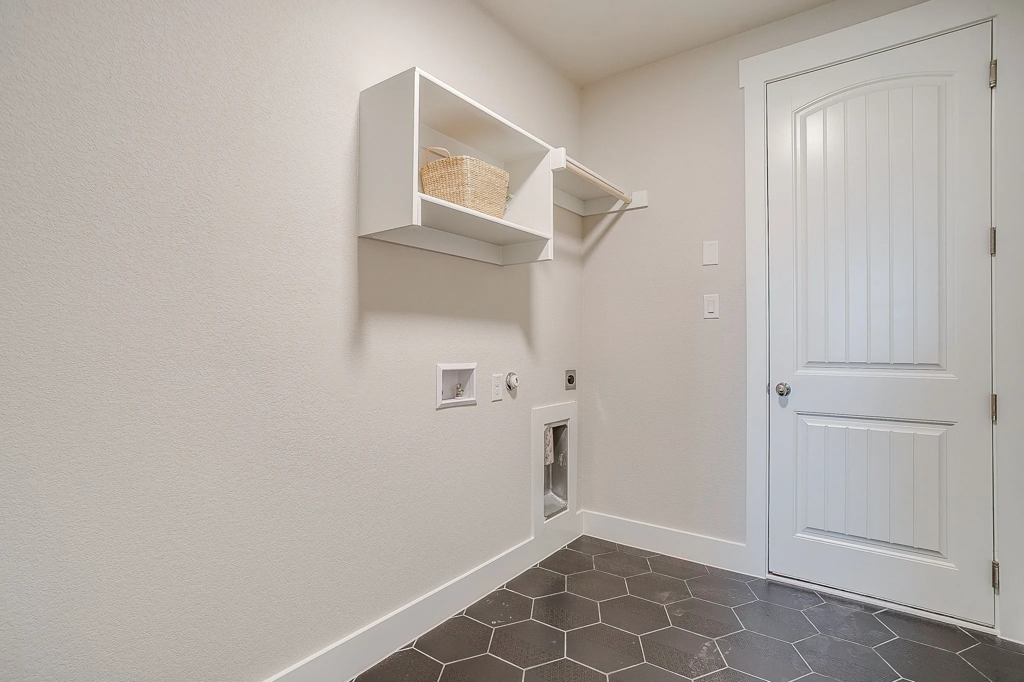 Hexagonal floor tiling, dedicated appliance connections, built-in open shelving, and a hanging rod