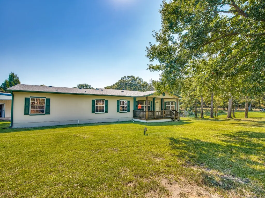 Single-story residence featuring a covered front porch, green shutters, and a well-maintained lawn