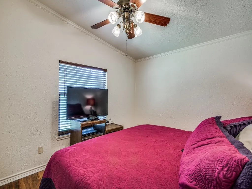 Vaulted ceiling with a wood-finish ceiling fan and chandelier