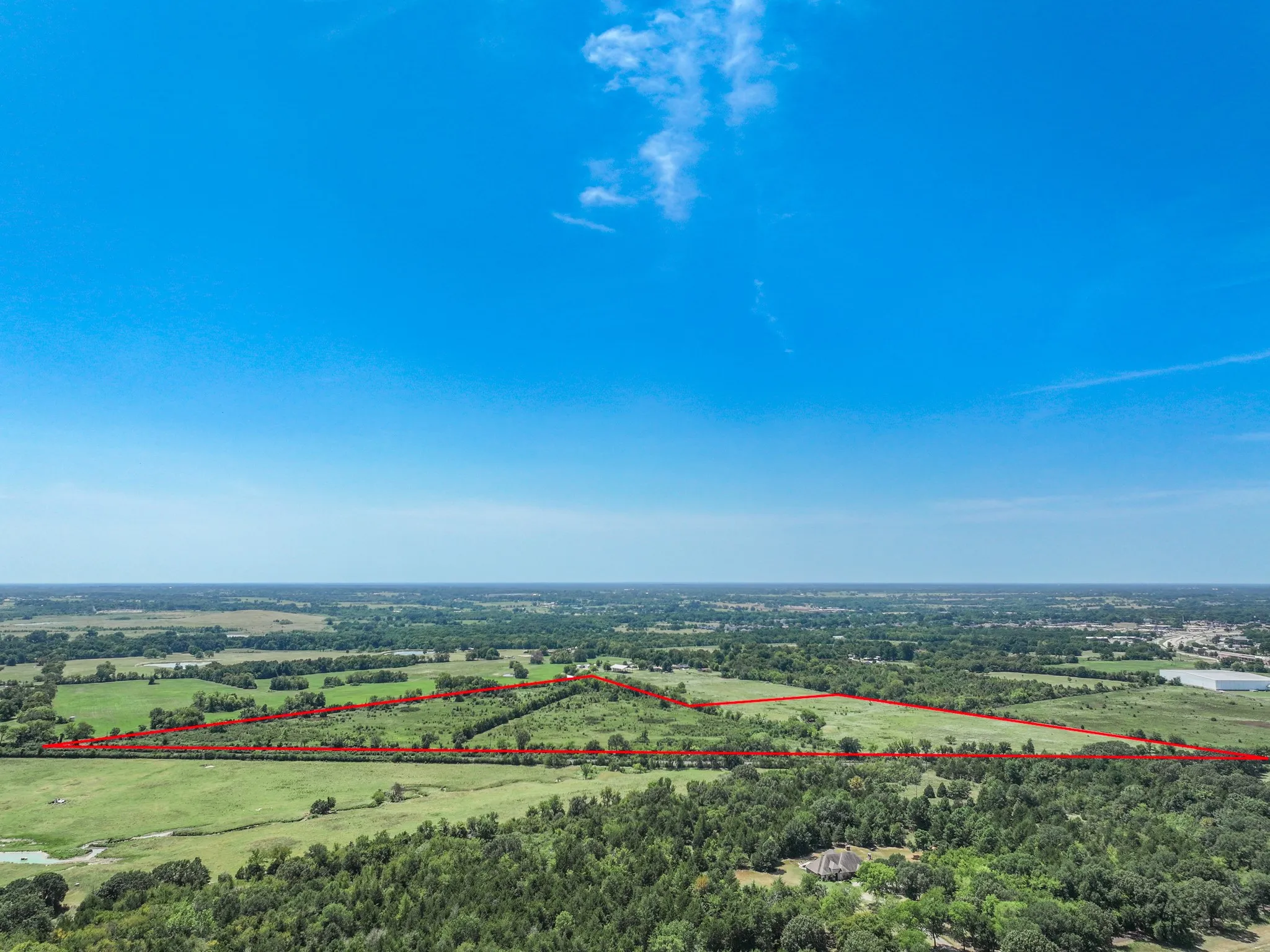 Expansive undeveloped acreage featuring a natural landscape and surrounding woodlands