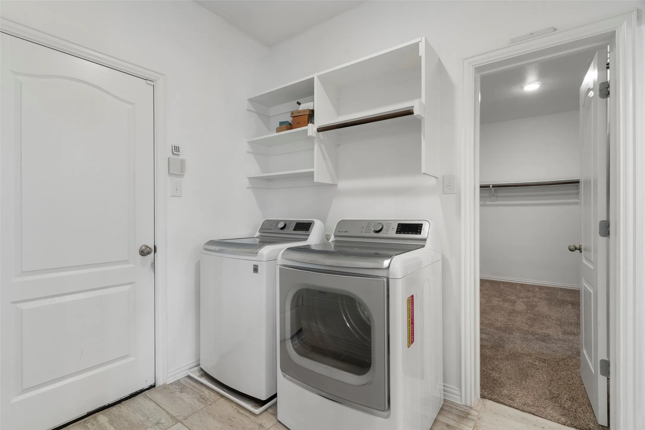 Laundry room with access to primary closet AND tons of storage space!