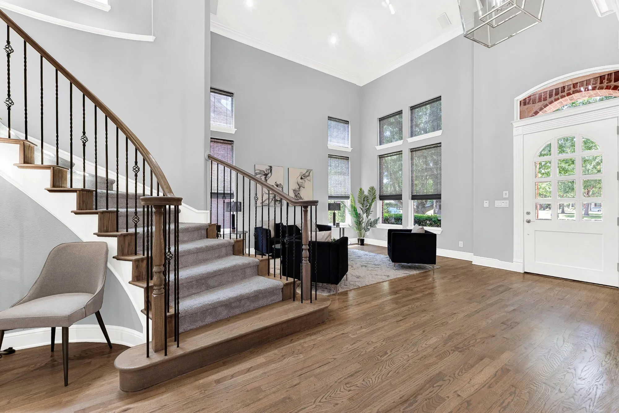 Soaring ceilings, gleaming hardwood floors, and a beautiful curved staircase with elegant iron spindles create a truly grand first impression from the front door. Imagine greeting guests in this dramatic, light-filled foyer as they arrive for a dinner party, making everyone feel instantly at home.