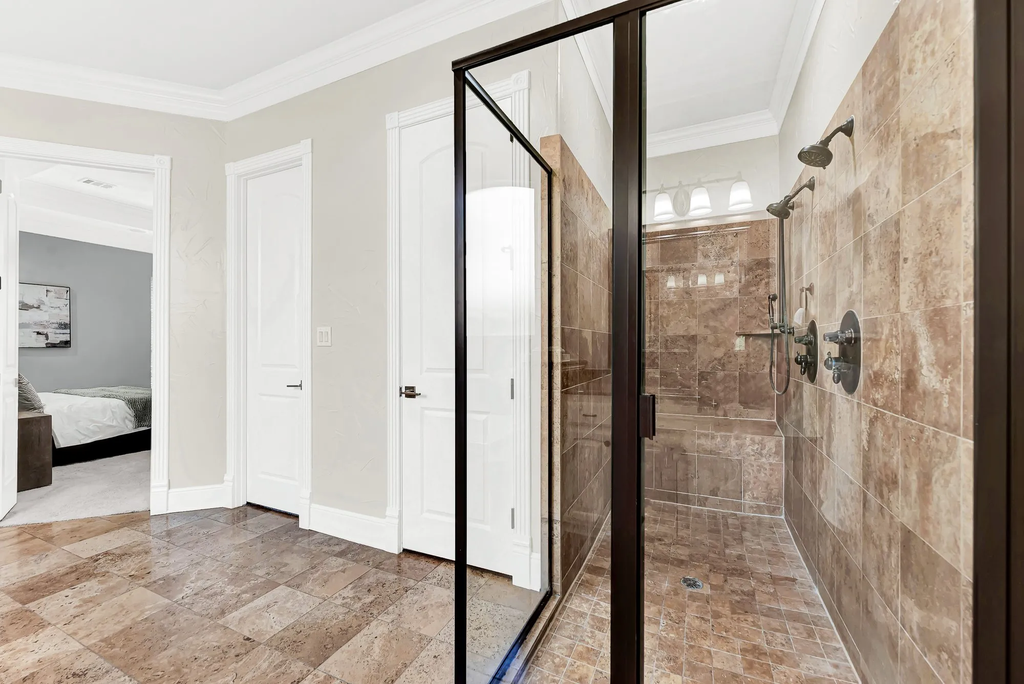 Framed in dark trim, this tiled walk-in shower features dual showerheads updated in 2026 for a modern spa experience. Enjoy a refreshing, high-end start to every morning right from the comfort of your home suite.