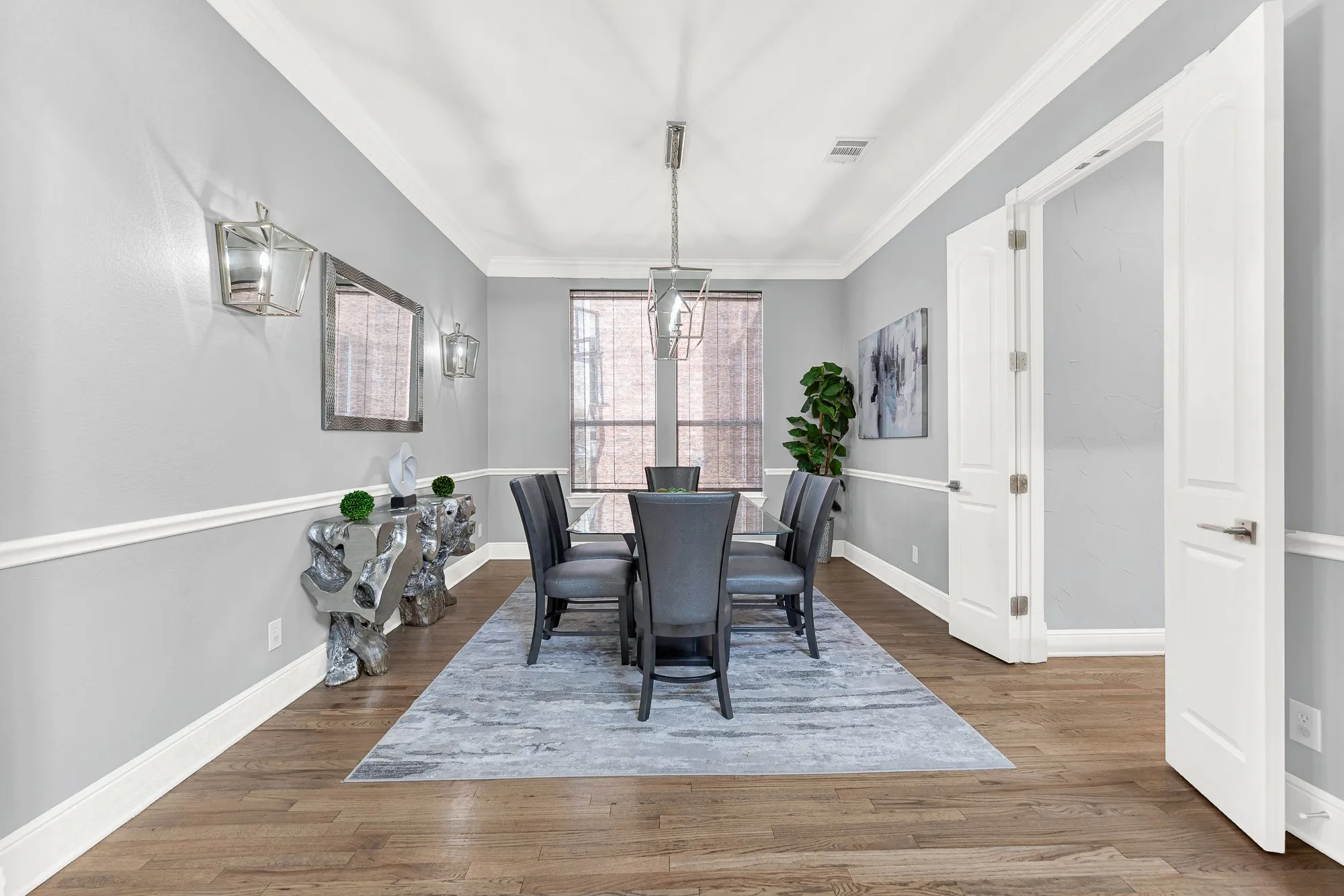 Crisp white wainscoting and elegant wall sconces add sophisticated texture to this intimate room, which receives lovely, soft light from the expansive windows. Host memorable, sophisticated holiday dinners or small family celebrations in this truly inviting and dedicated entertaining space.