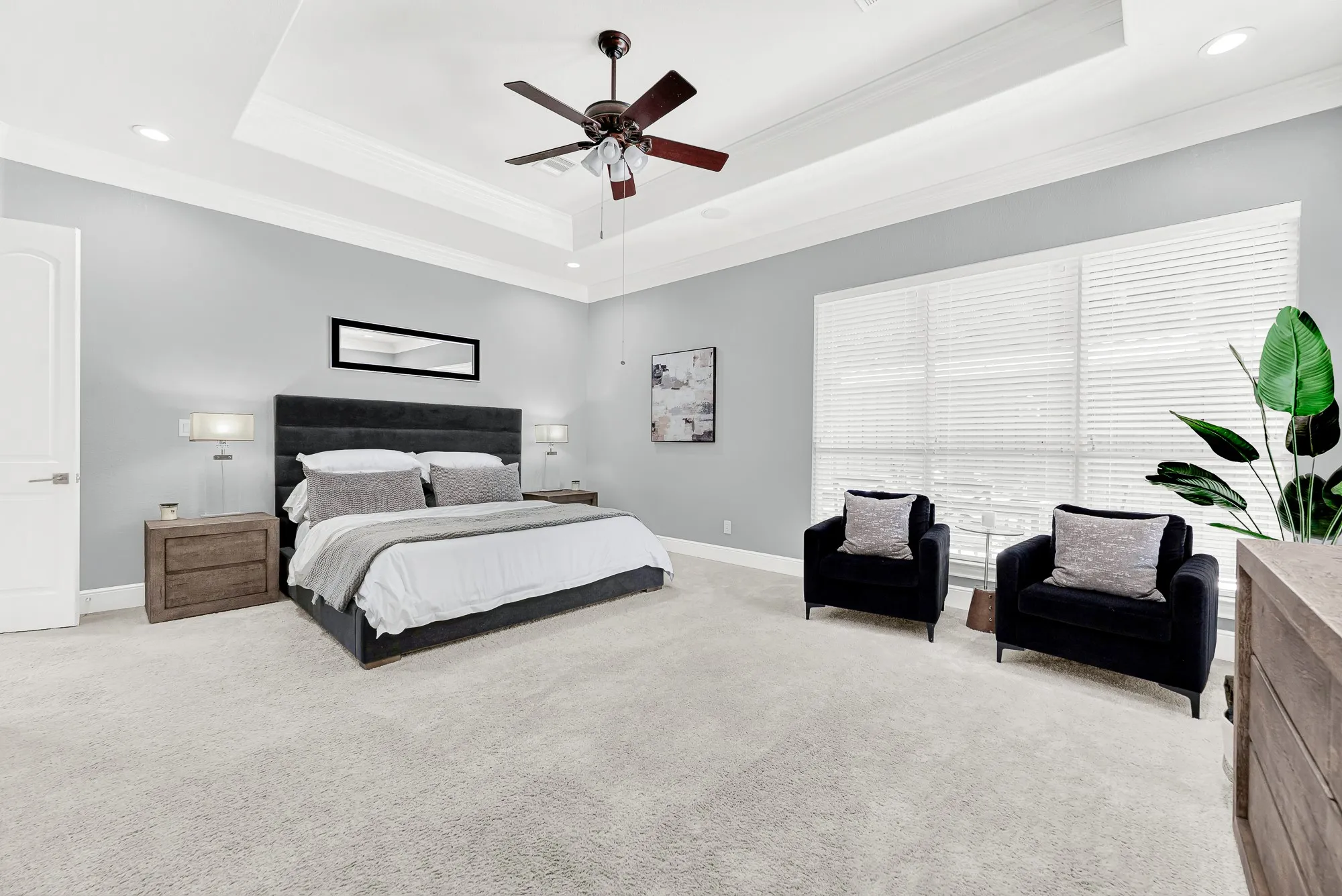 Soft plush carpeting, double tray ceilings, and updated windows fill this expansive primary suite with warmth and bright natural light. Unwind peacefully after a long day in your private sanctuary with plenty of room to stretch out and relax.