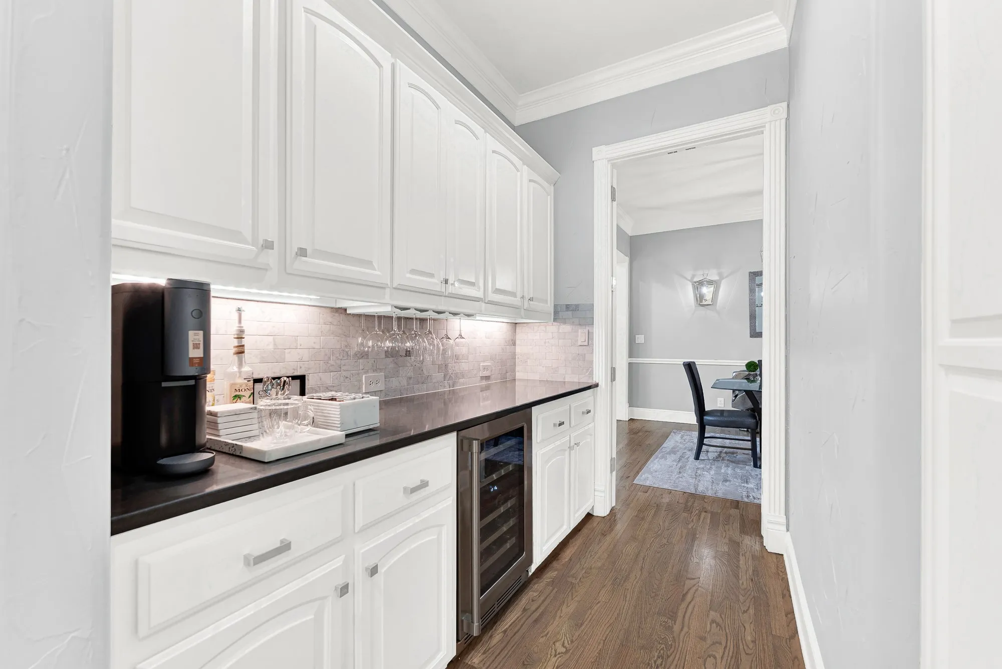 Equipped with a dual-zone Zephyr wine fridge, this butler's pantry leads directly into the formal dining room. Pour your favorite vintage and serve guests effortlessly during dinner parties without missing a single beat.