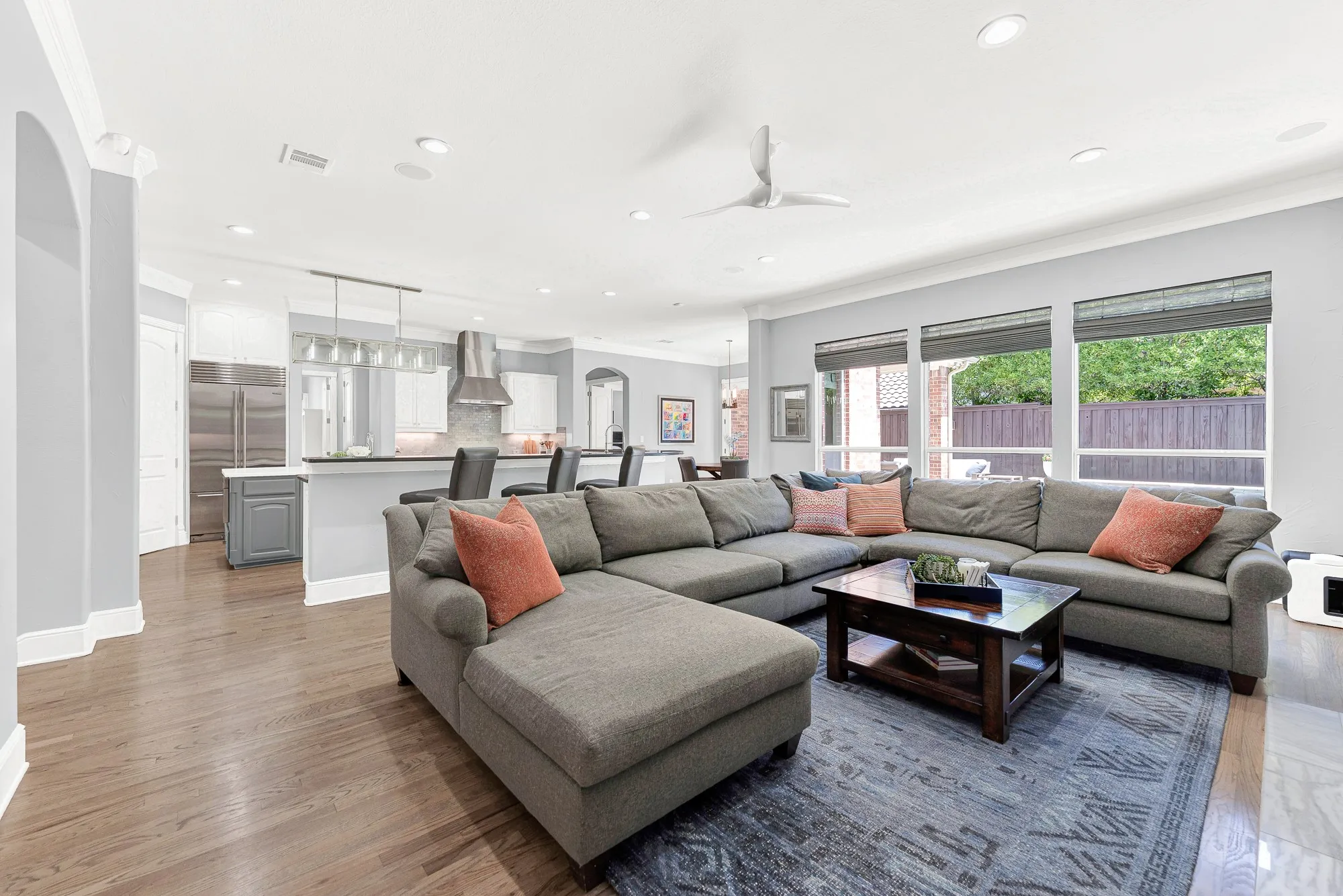 Large picture windows flood the open family room with sunlight while offering clear, inviting views of the shimmering pool and patio outdoors. Gather loved ones for casual weekend hangs while keeping an easy eye on backyard swimming and outdoor festivities.