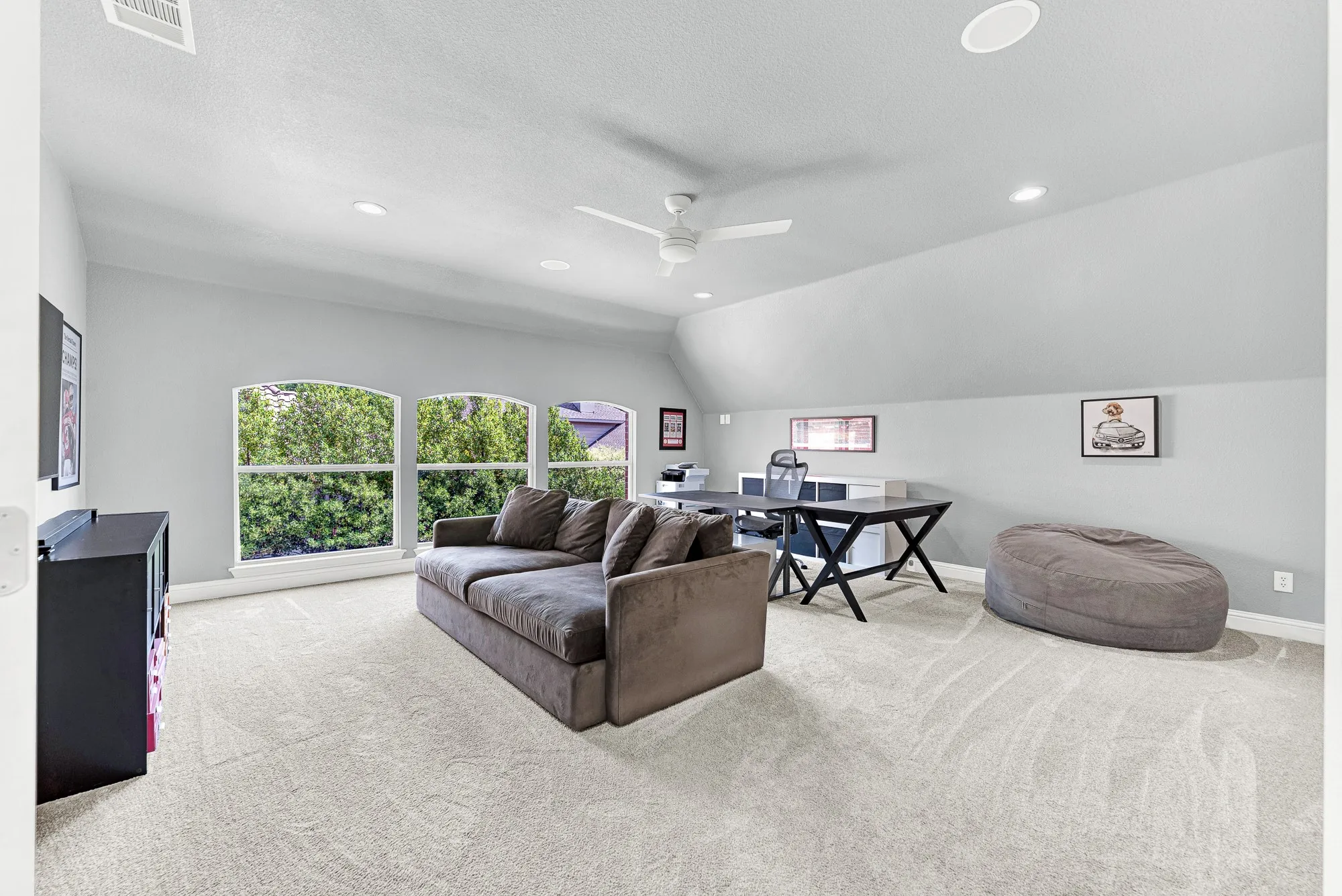 A trio of arched windows floods this spacious bonus room with natural light while plush carpeting and sloped ceilings create a cozy feel. Easily tailor this multi-purpose space into a quiet home office, lively play room, or an additional bedroom to suit your family's needs.