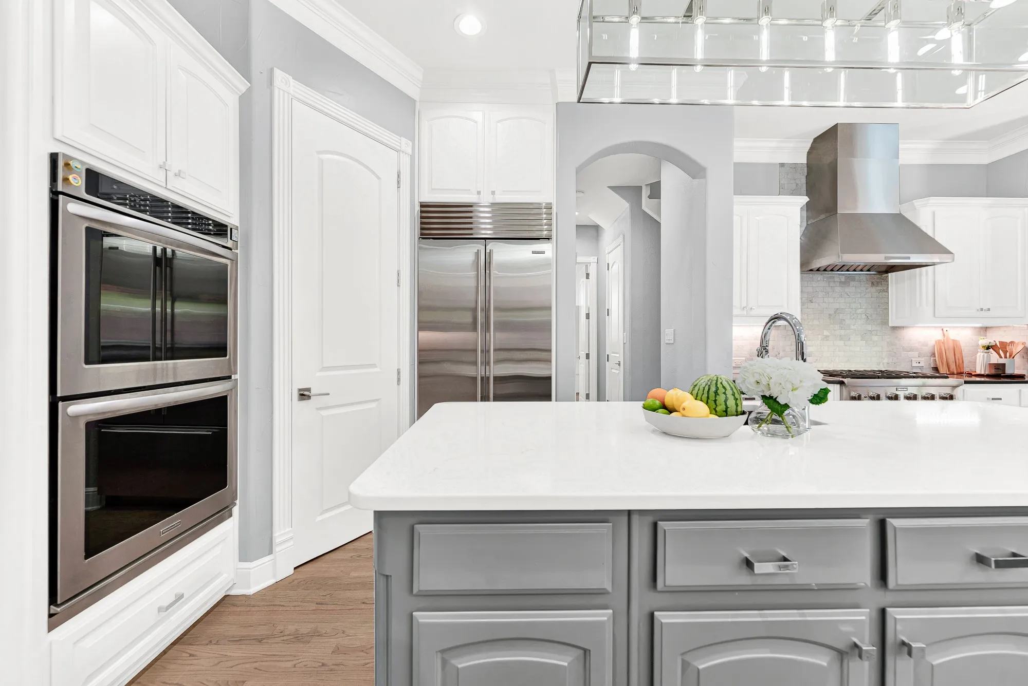 Double wall convection ovens and custom cabinetry anchor this high-end prep corner right beside the Sub-Zero refrigerator. Hosting holiday feasts feels smooth and stress-free when you have professional-grade appliances right at your fingertips.