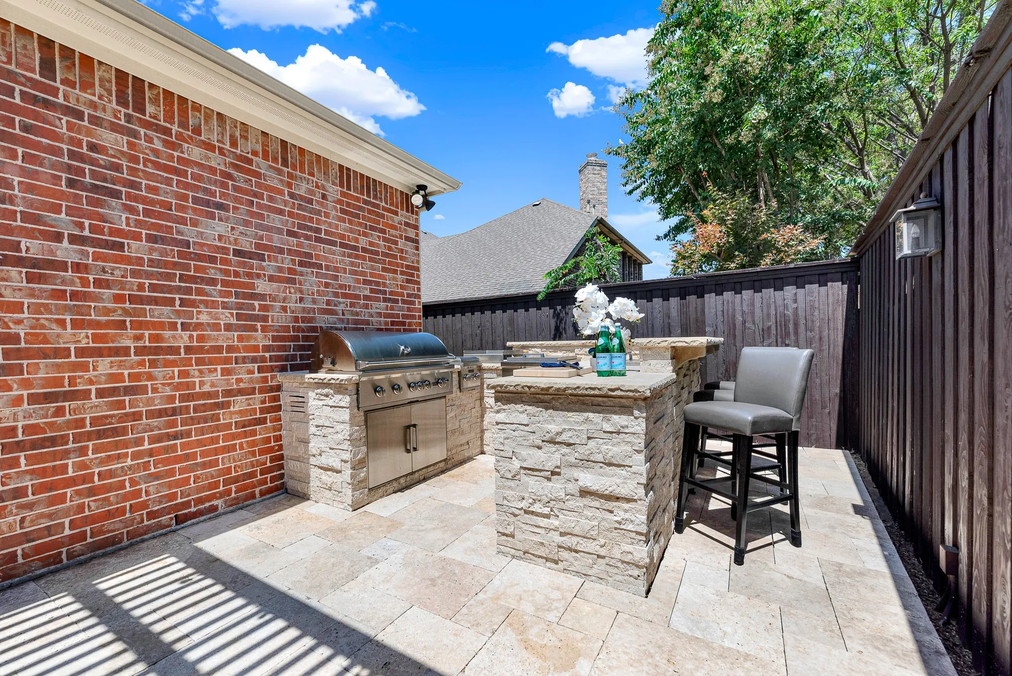 Built into stacked stone, the outdoor kitchen features a Coyote 42" grill, double side burner, and griddle. Treat your guests to weekend barbecues and gourmet meals right in the backyard.