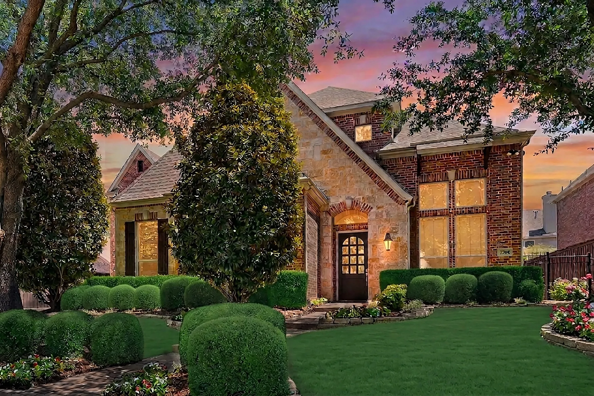 Beautifully manicured front lawn framed by mature trees and thoughtfully sculpted landscaping, creating an inviting and elegant first impression.