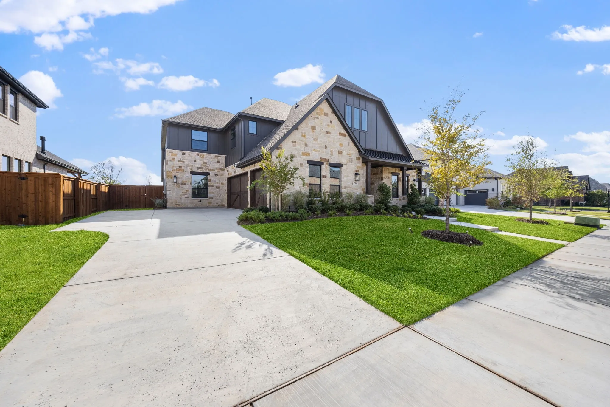 The beautiful light colored stone exterior and brick accents paired with striking dark board & batten create a dream home filled with curb appeal!