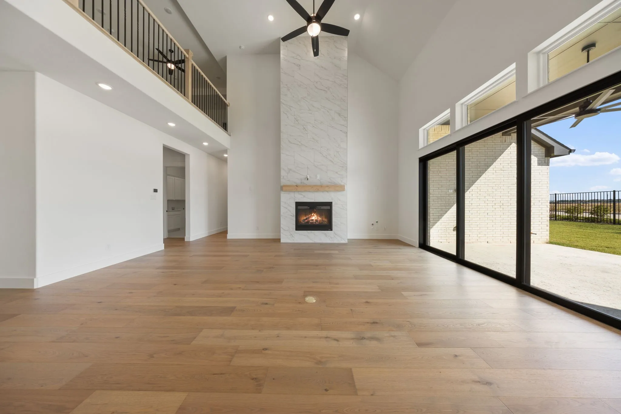 Featuring soaring ceilings, a stunning floor to ceiling fire place and full wall slider, this family room is the ideal space for the family to gather.