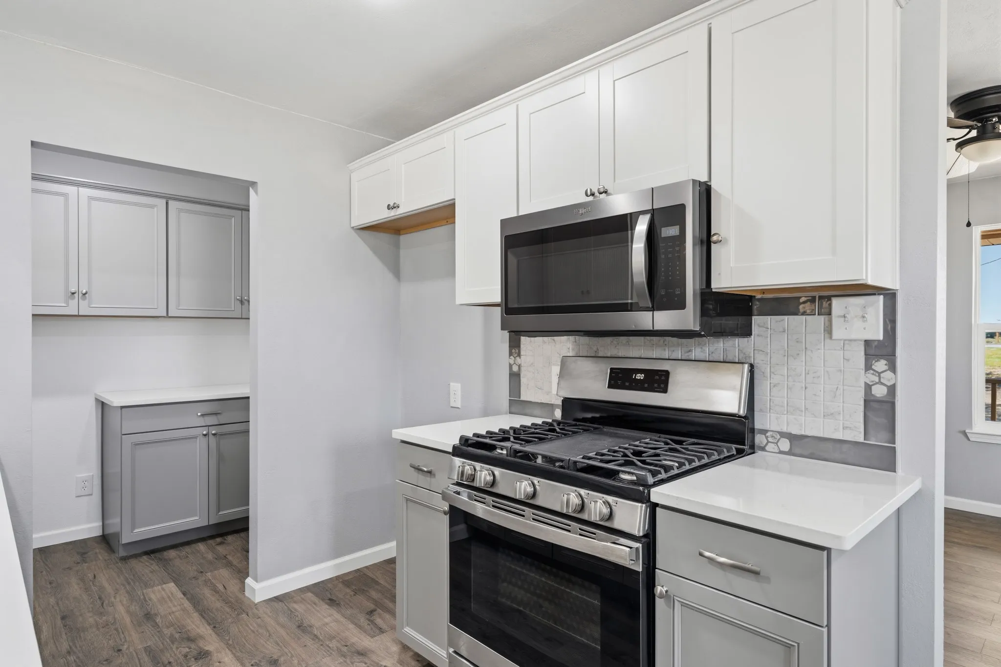 White shaker-style upper cabinetry with stainless steel hardware