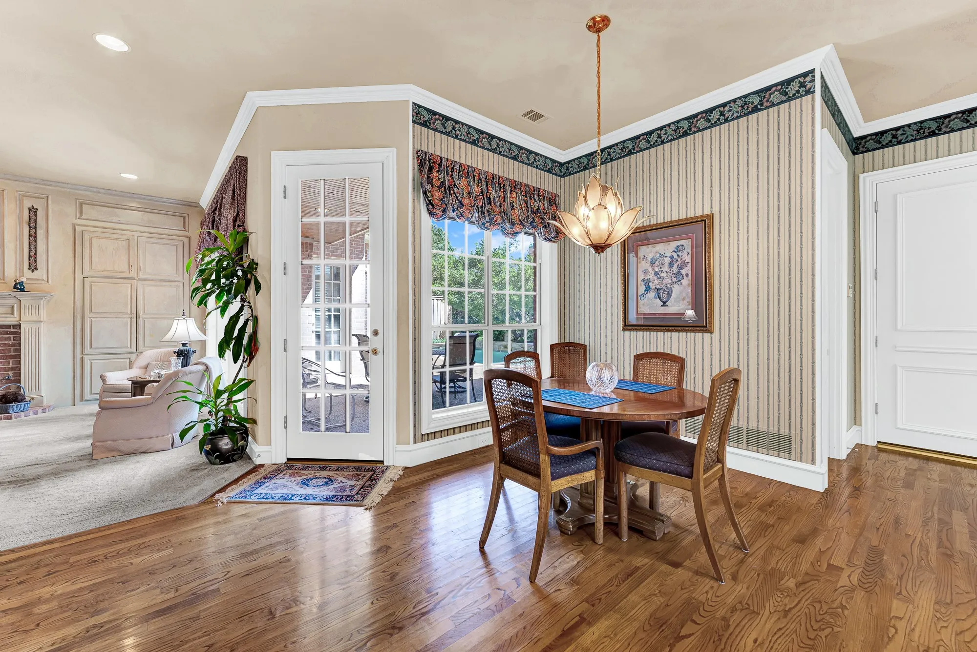 A French door opens directly to the covered patio, drawing pool views and fresh breezes into the alcove. Start quiet weekend mornings with fresh pastries while enjoying seamless indoor-outdoor living.