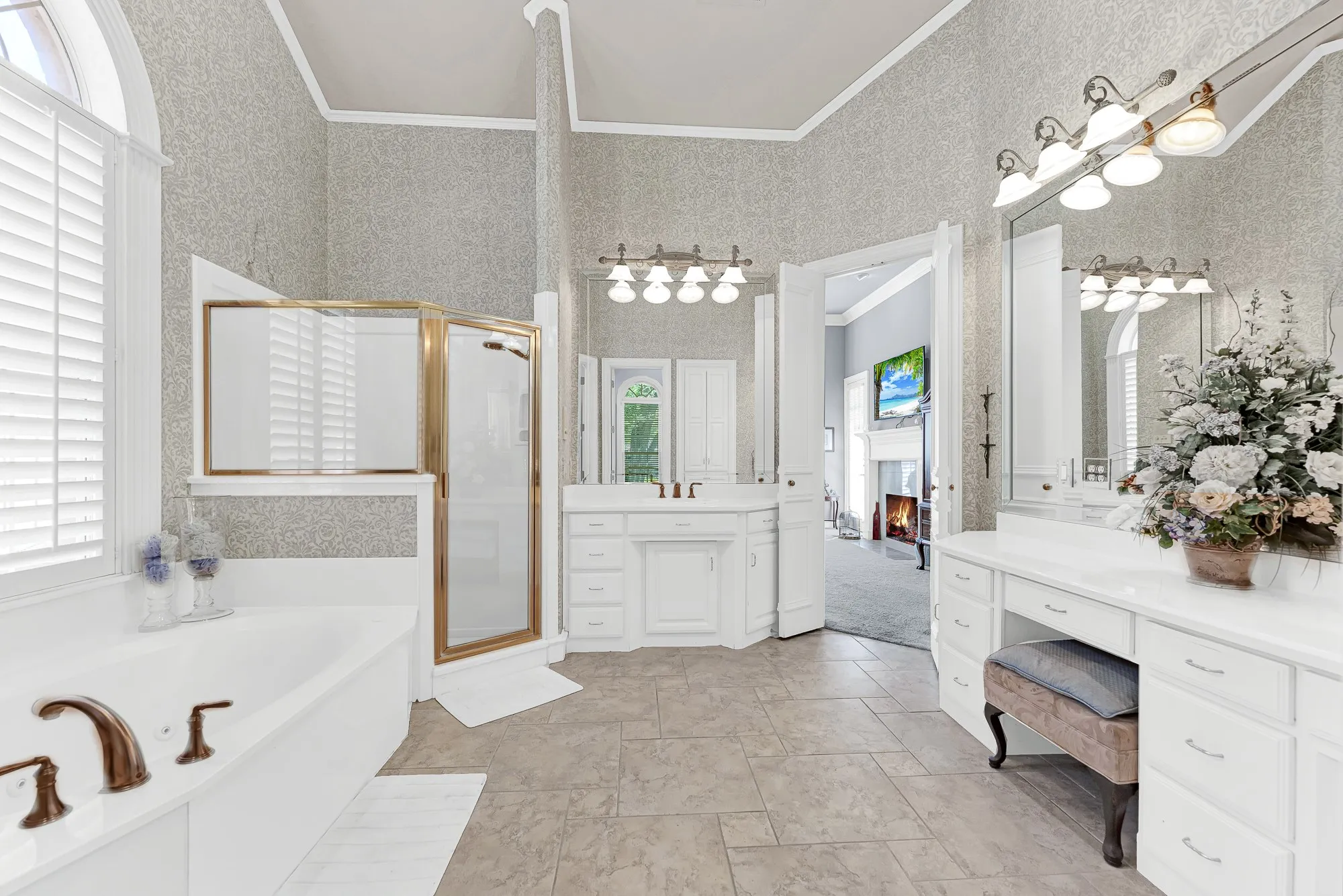 Soaring vaulted ceilings accentuate separate vanity stations linked by bright overhead lighting. Prepare effortlessly for your day alongside your partner in this open layout.