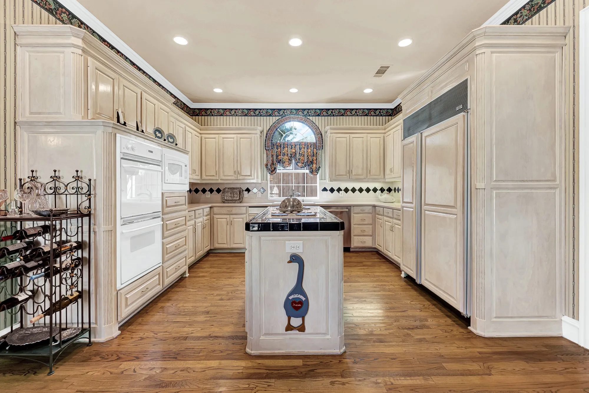 *FABULOUS REMODEL OPPURTUNITY* Seamless custom cabinetry frames an efficient cook's layout, bathed in soft recessed lighting. Imagine prepping homemade pizza crusts across smooth counters while kids chat about their school day.