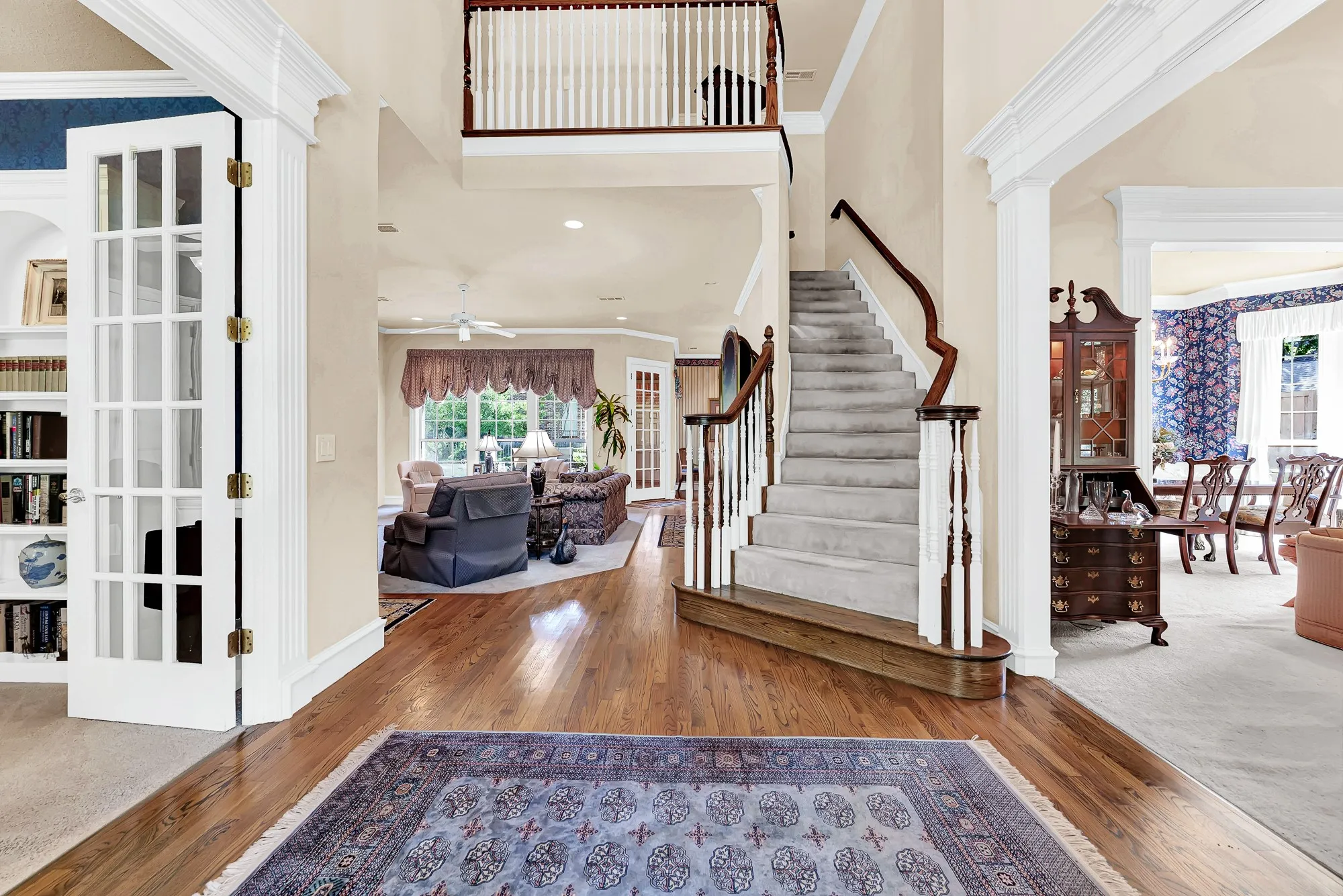 A graceful, curved staircase anchors the double-height foyer with classic, architectural elegance. Imagine the excitement of gathering loved ones here for festive holiday photos before dinner.