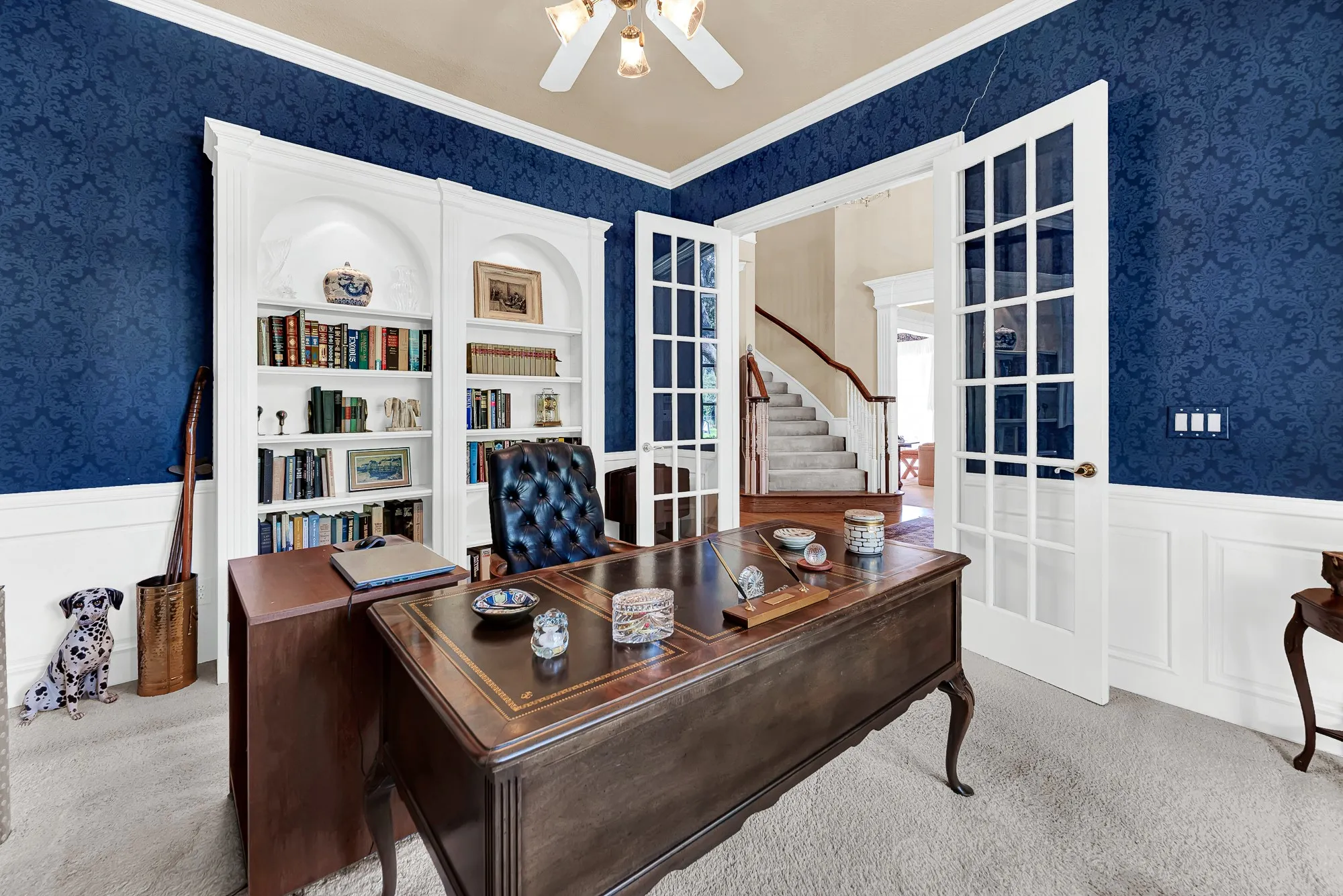 Built-in arched shelving framed by double French doors creates a refined, private sanctuary. Enjoy a quiet evening curling up here with a favorite book after a productive day.