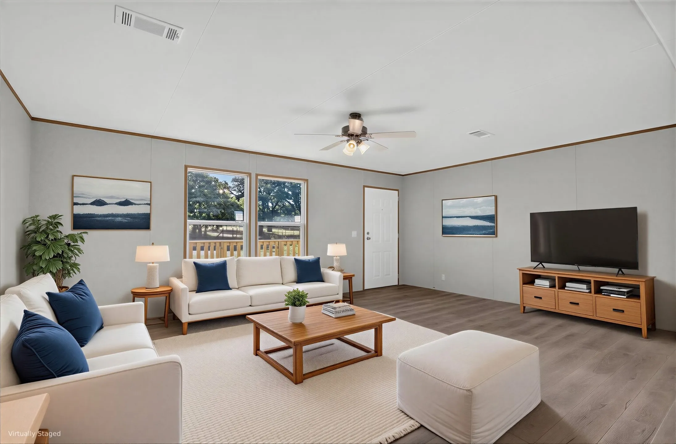 Spacious living area featuring wood-finish flooring, a ceiling fan, and large windows.
Furniture is Virtually Staged